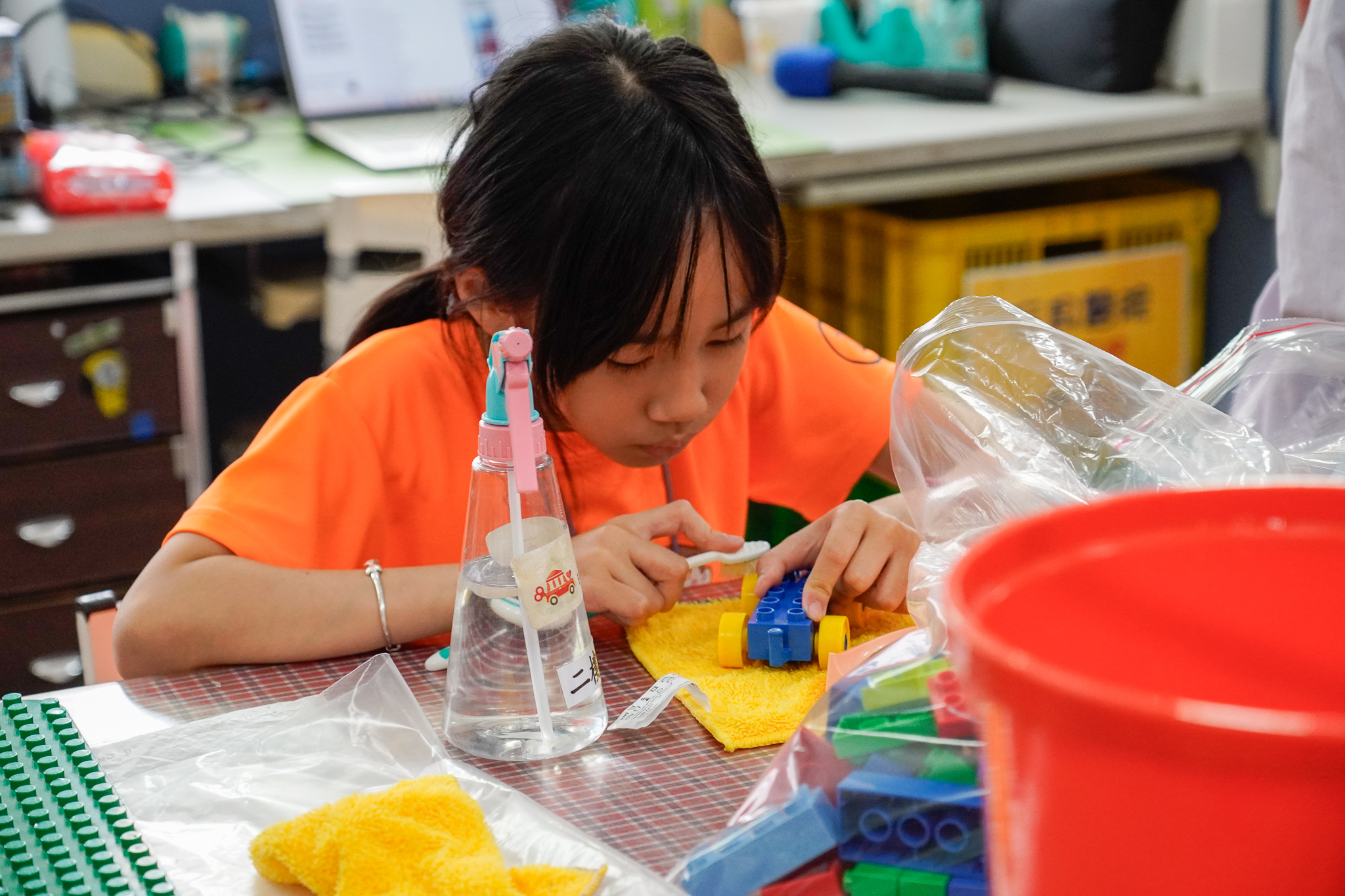 小小志工使用牙刷清潔玩具細小縫隙，相當細心