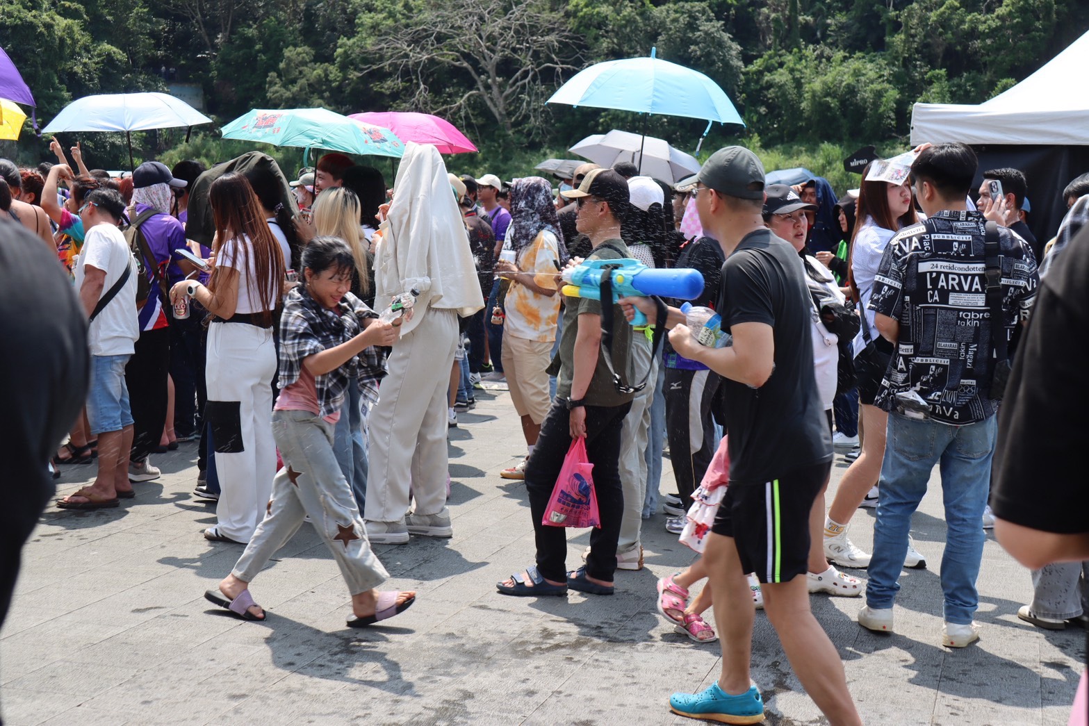 許多家長幫孩子準備大型水槍，泰辦也贈送小水槍，大家互相噴水、抹涼粉消暑同樂。