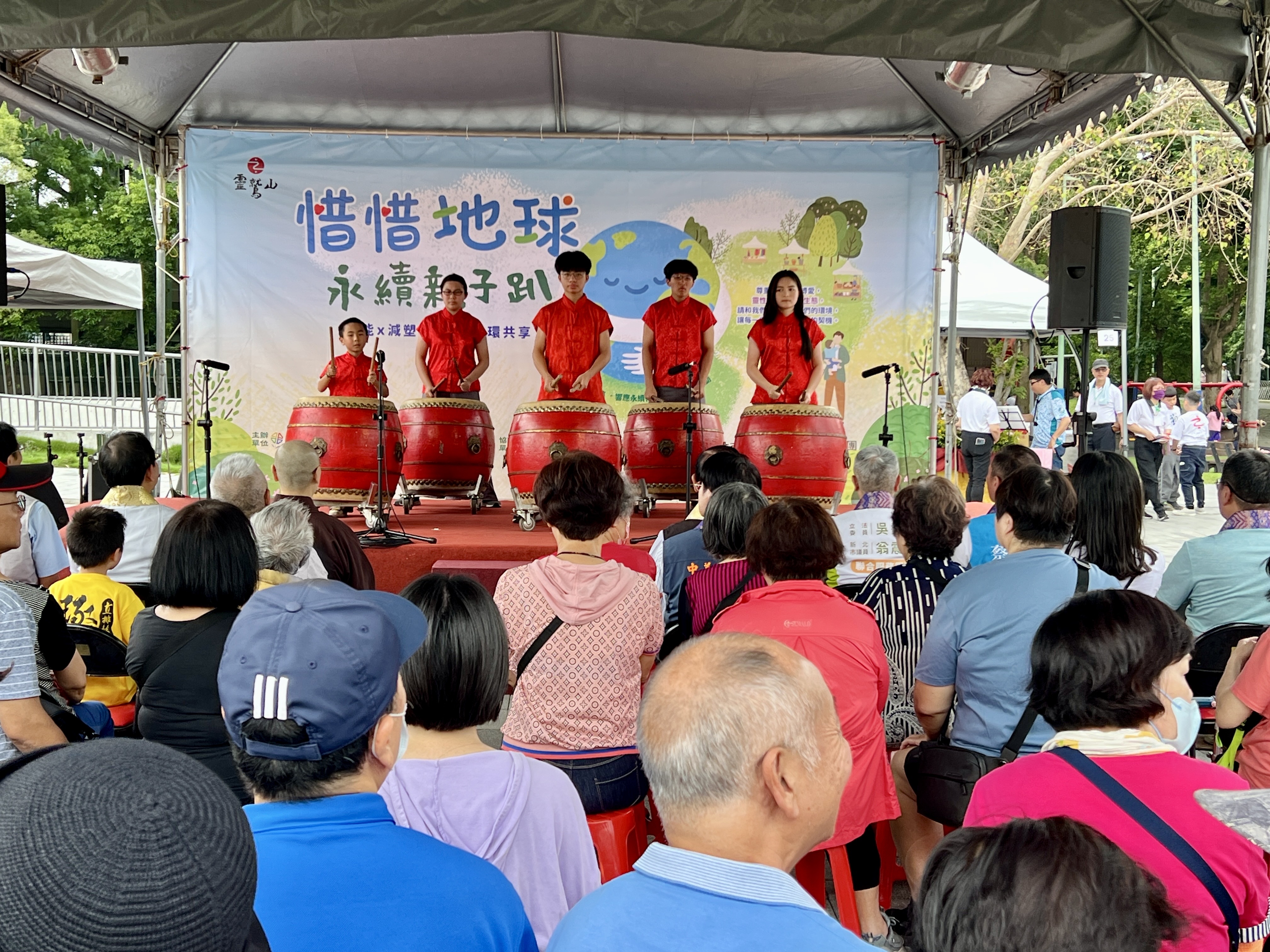 靈鷲山佛教團今於新莊區綜合體育場林蔭大道舉辦「2025惜惜地球永續親子趴」，由新莊鼓藝隊帶來開場表演。