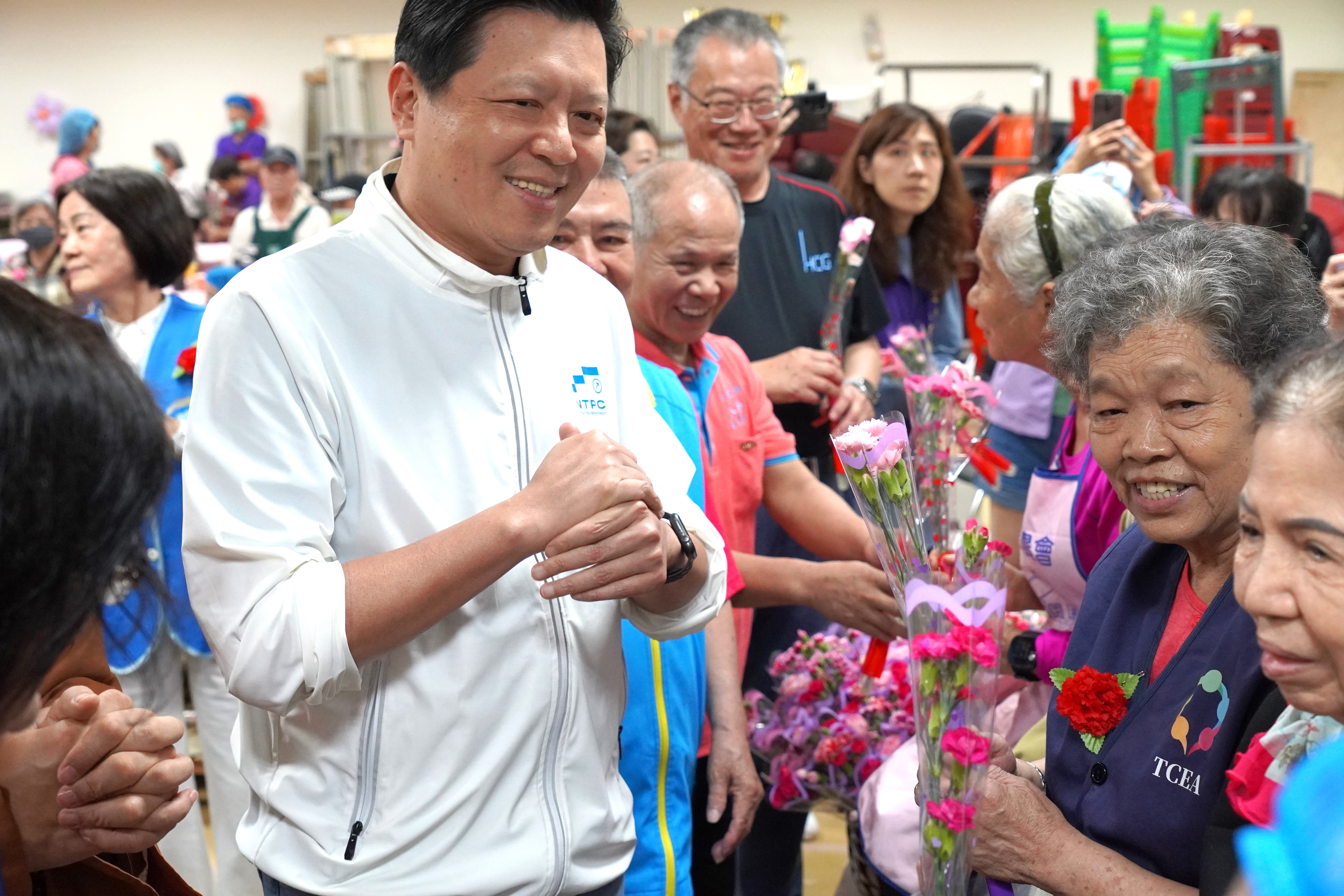 新北市副市長朱惕之親自獻花給高齡志工表達感謝，也祝福大家母親節快樂及端節平安