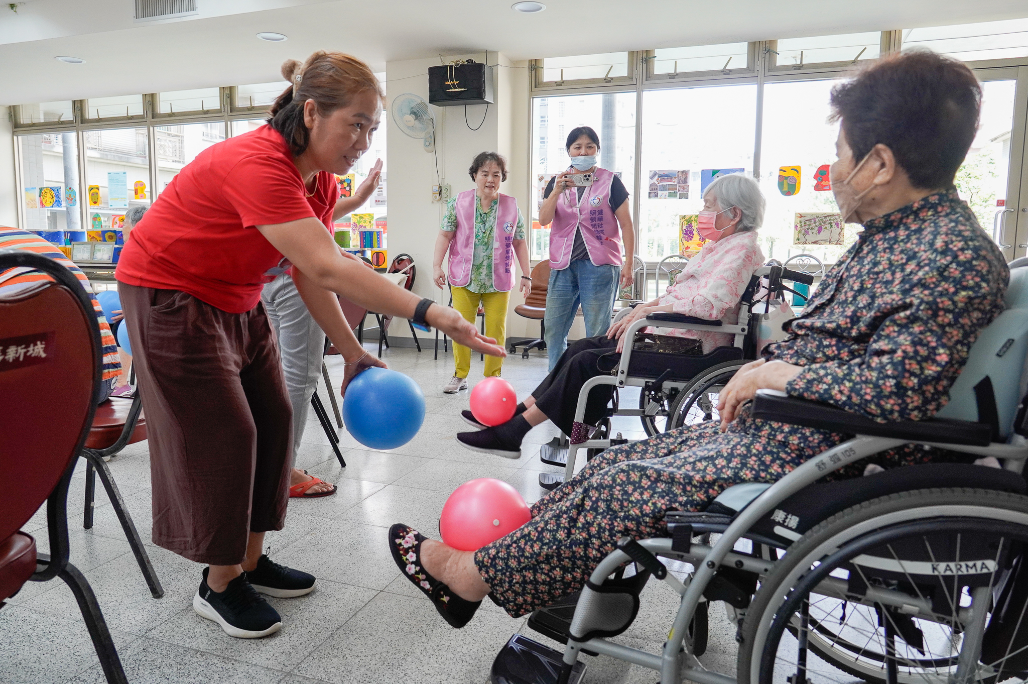 志工鼓勵長輩用力讓下肢可以伸展抬起球來
