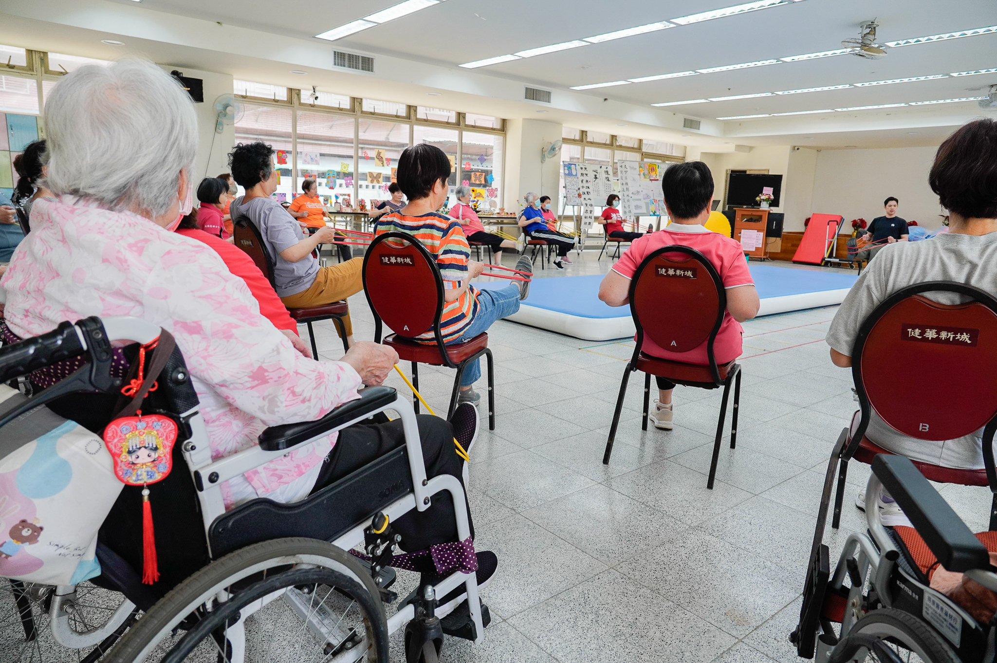 坐在輪椅上的長輩，也都學會用彈力帶伸展下肢