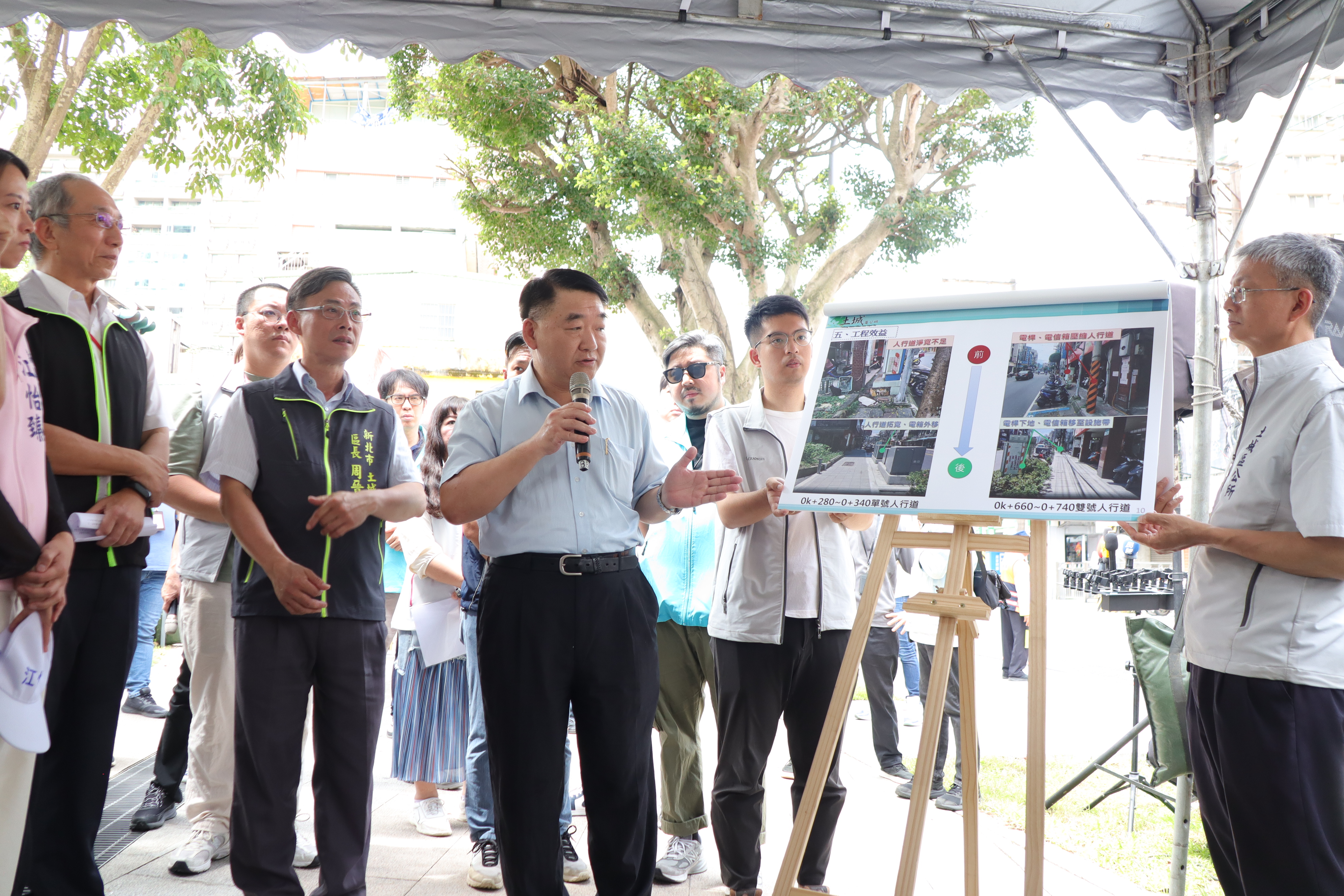 工務局長馮兆麟(持麥克風者)補充說明土城中央路1、2段人行道改善，未來台電將把66支電桿下地。