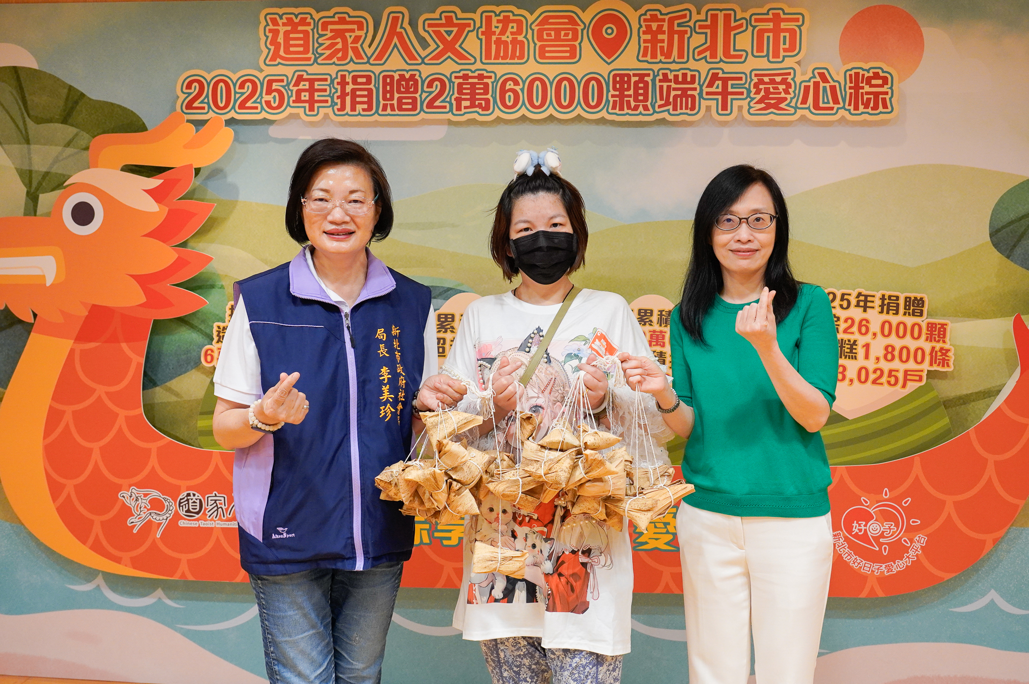 道家人文協會理事長張旖(右1)代表捐贈愛心粽，與新北社會局長李美珍(左1)一同將粽子給予受贈代表小錡(中)。