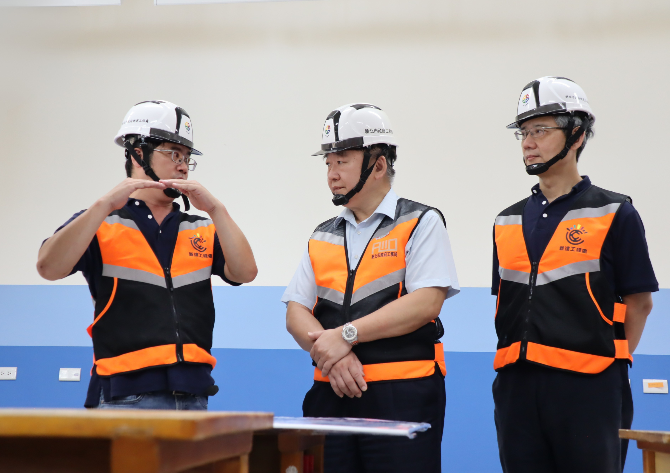 工務局長馮兆麟(中)、新工處長簡必琦(右一)聆聽新工處同仁說明校舍改建工程內容。
