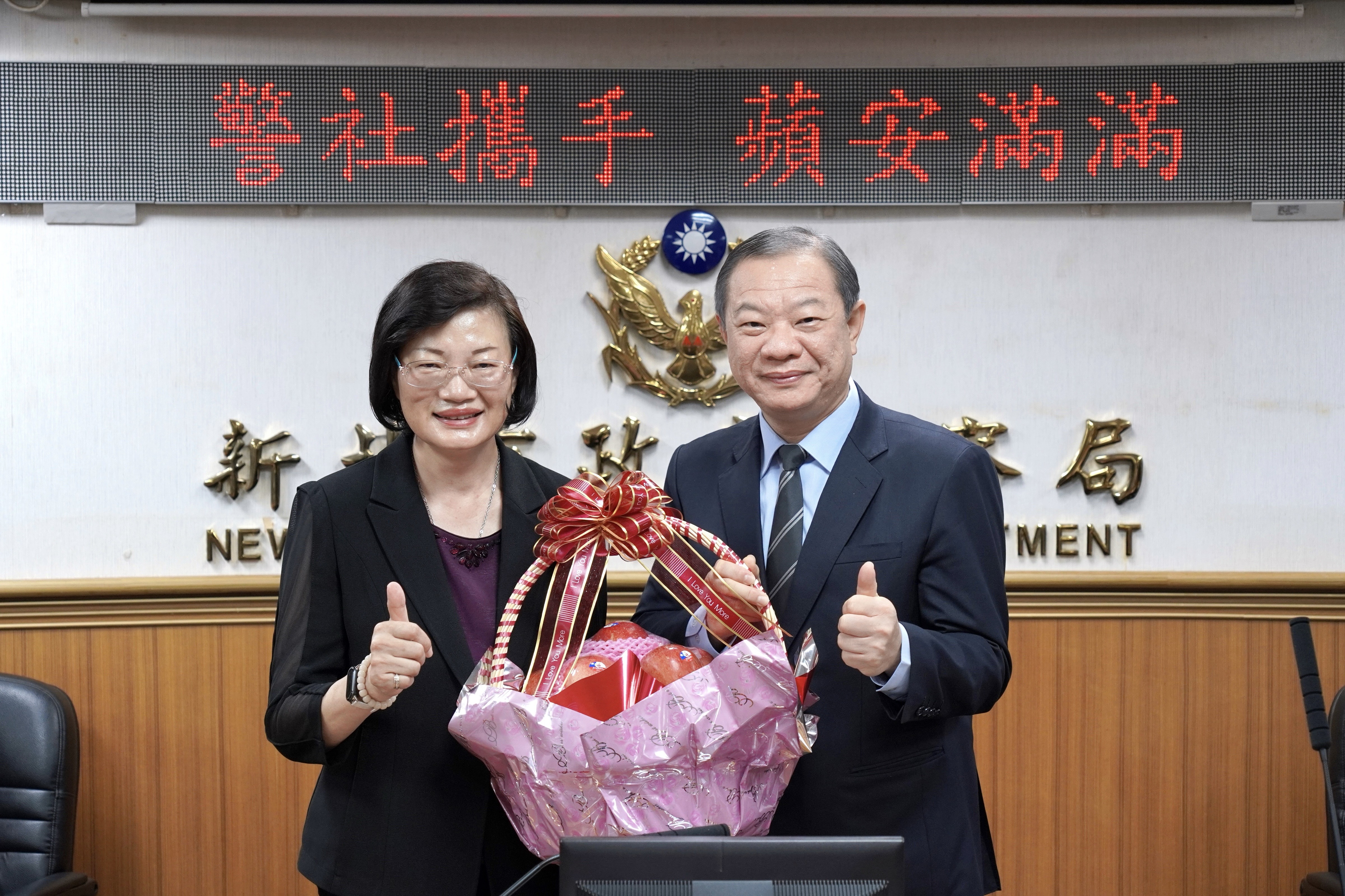 社會局長李美珍(左)代表致贈象徵「平安」的蘋果，由警察局長廖訓誠(右)代表收下。