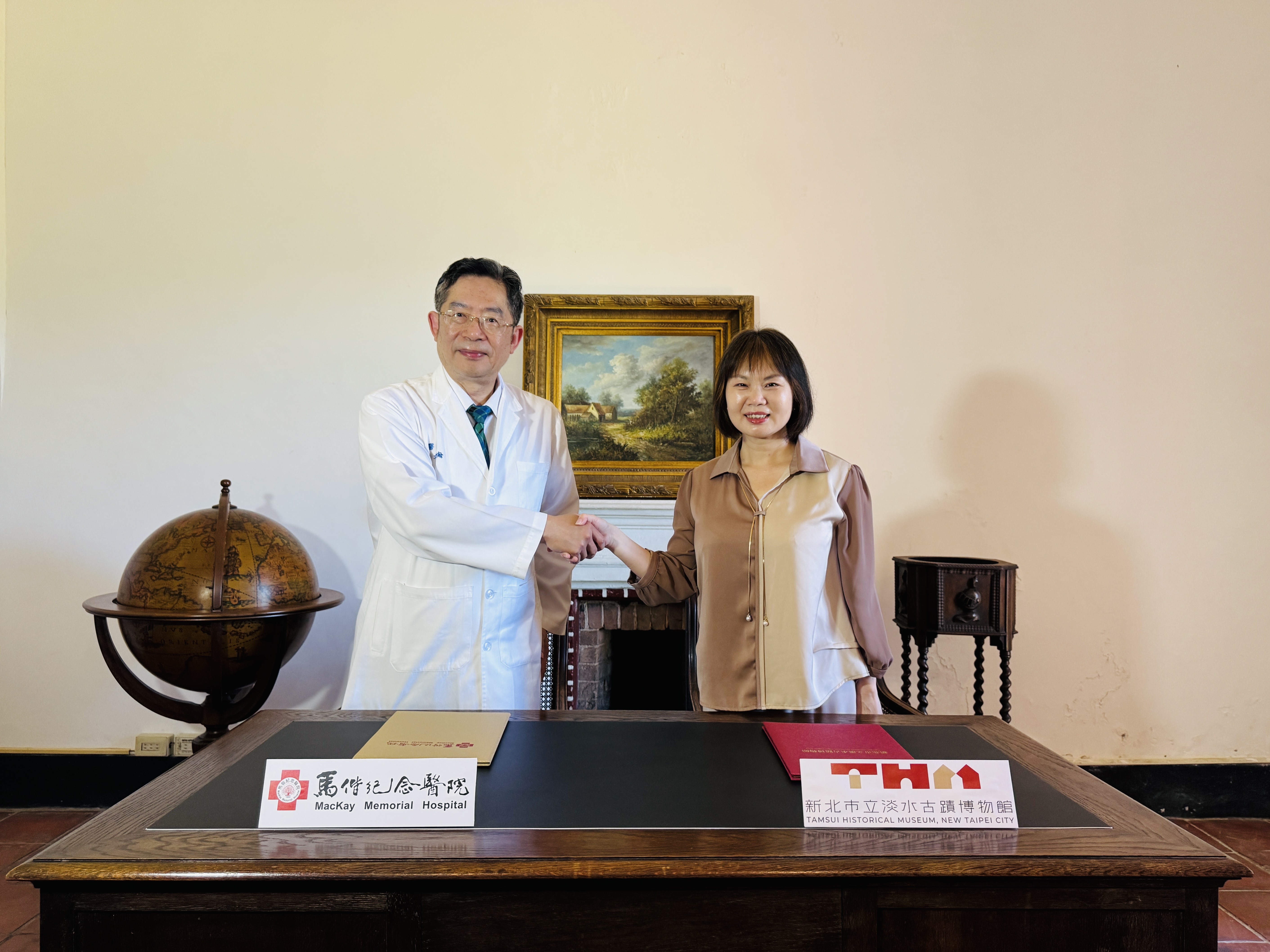 淡水古蹟博物館館長蔡美治（右）與馬偕紀念醫院總院長張文瀚於淡水紅毛城領事辦公室簽署合作備忘錄，攜手打造失智友善文化場域。