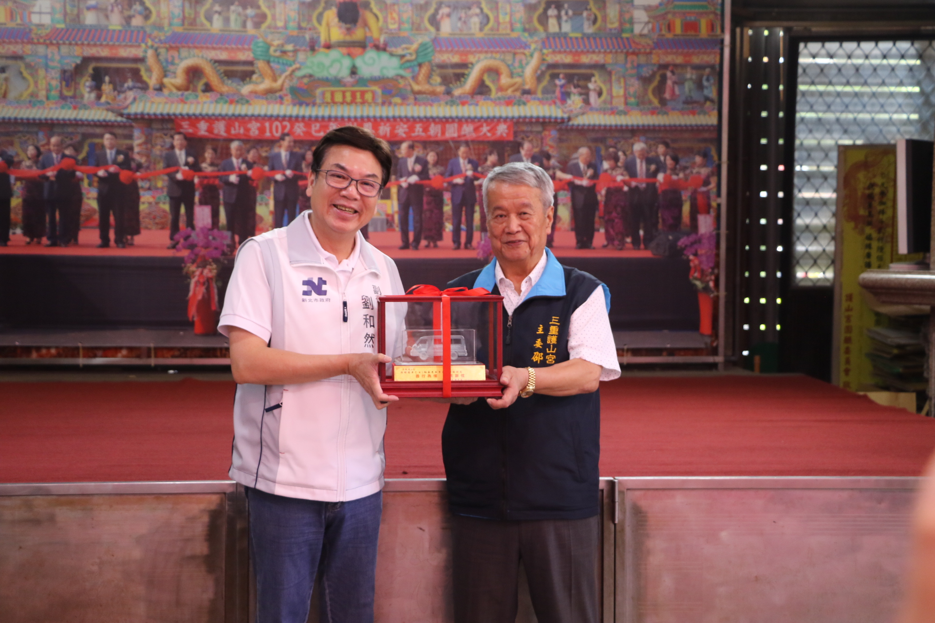  劉和然代表侯友宜市長回贈復康巴士模型車給邵德（右）