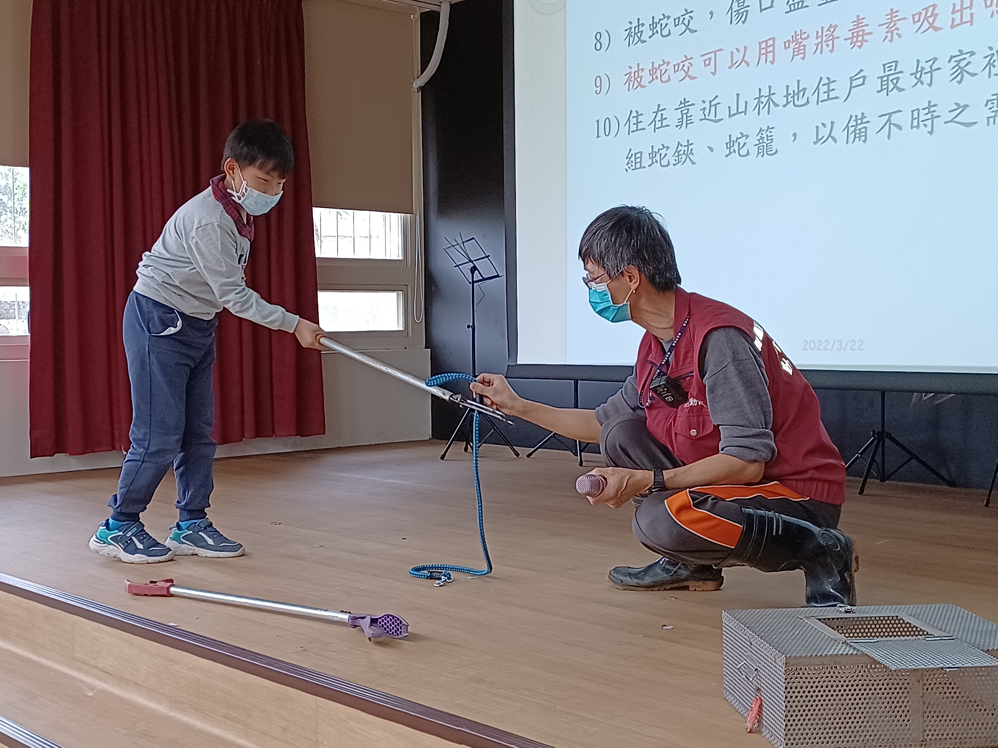 圖五、動保員指導社區民眾小朋友如何使用蛇籠蛇鋏技巧。