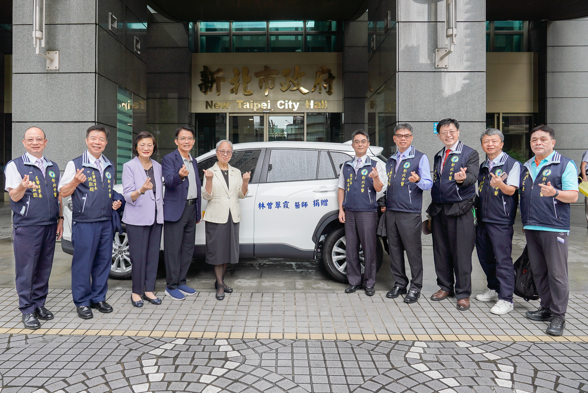 林曾翠霞醫師(左5)捐贈社福專車予新北市社會局北海岸社福中心，率新北市中醫師公會見證及合影，並由市府秘書長邱敬斌(左4)代表受贈