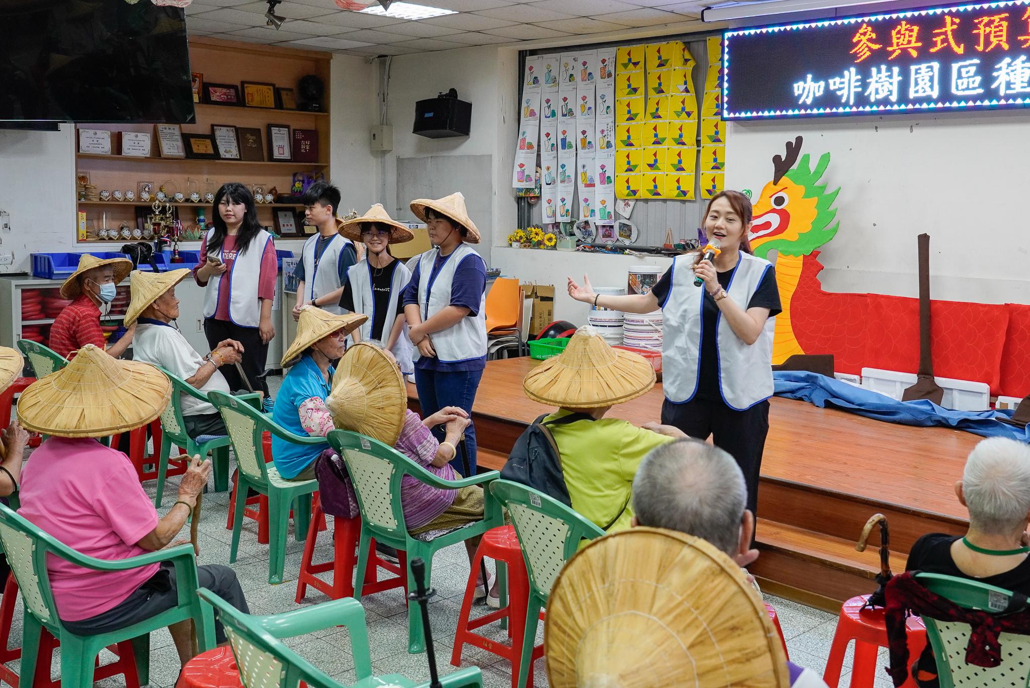 新莊少年中心主任許巽絜（持麥者）表示，「青銀童樂會之夏日咖啡園」是由少年自己討論規劃活動內容