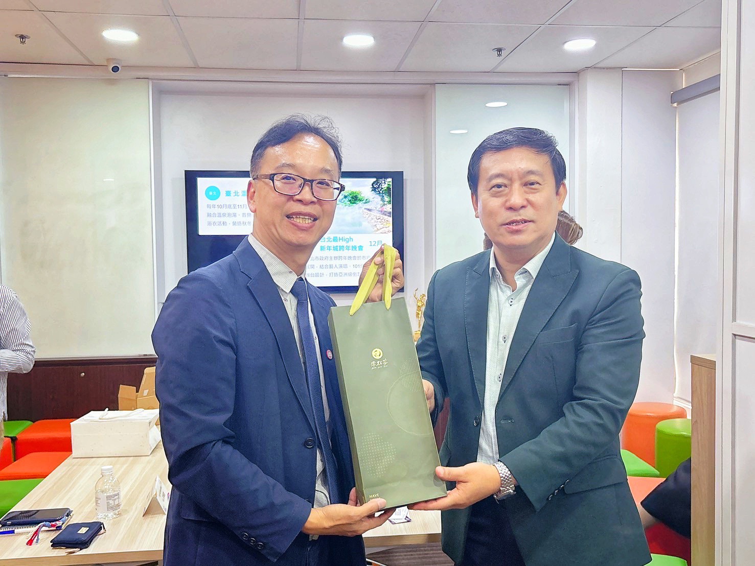  新北觀旅局楊宗珉局長（左）在拜會大通旅行社時致贈坪林茶點。