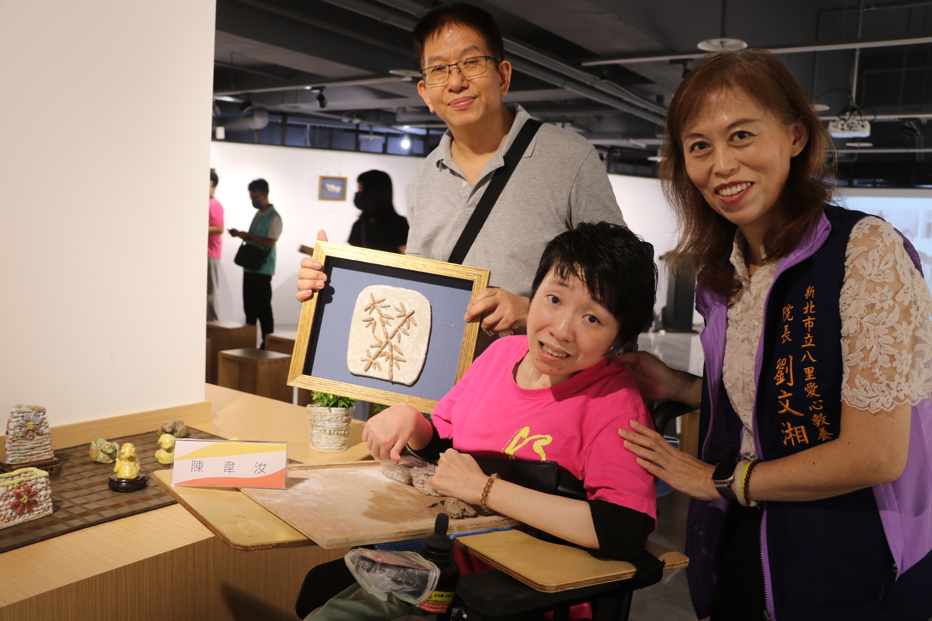  韋汝展出自己的作品黃色小鴨和綠頭鴨及竹子 左1為指導老師張耀全 右1為八里愛心教養院院長劉文湘