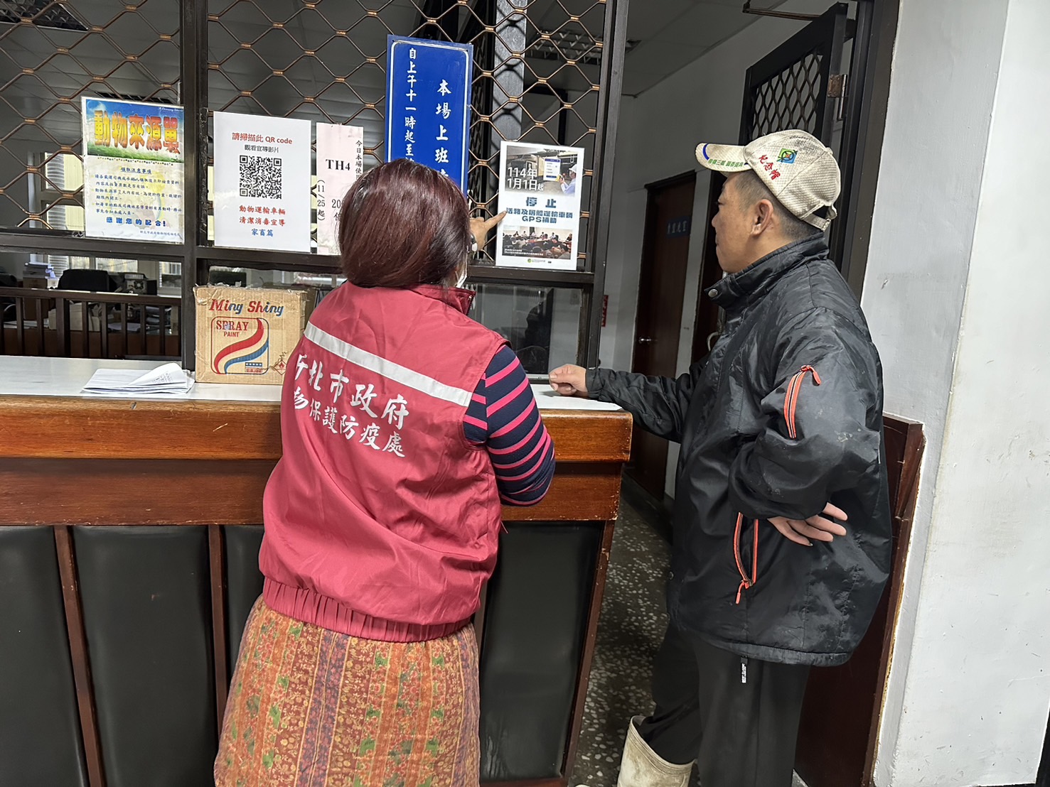  防疫人員向運豬車司機說明GPS停止補助宣導單張內容。