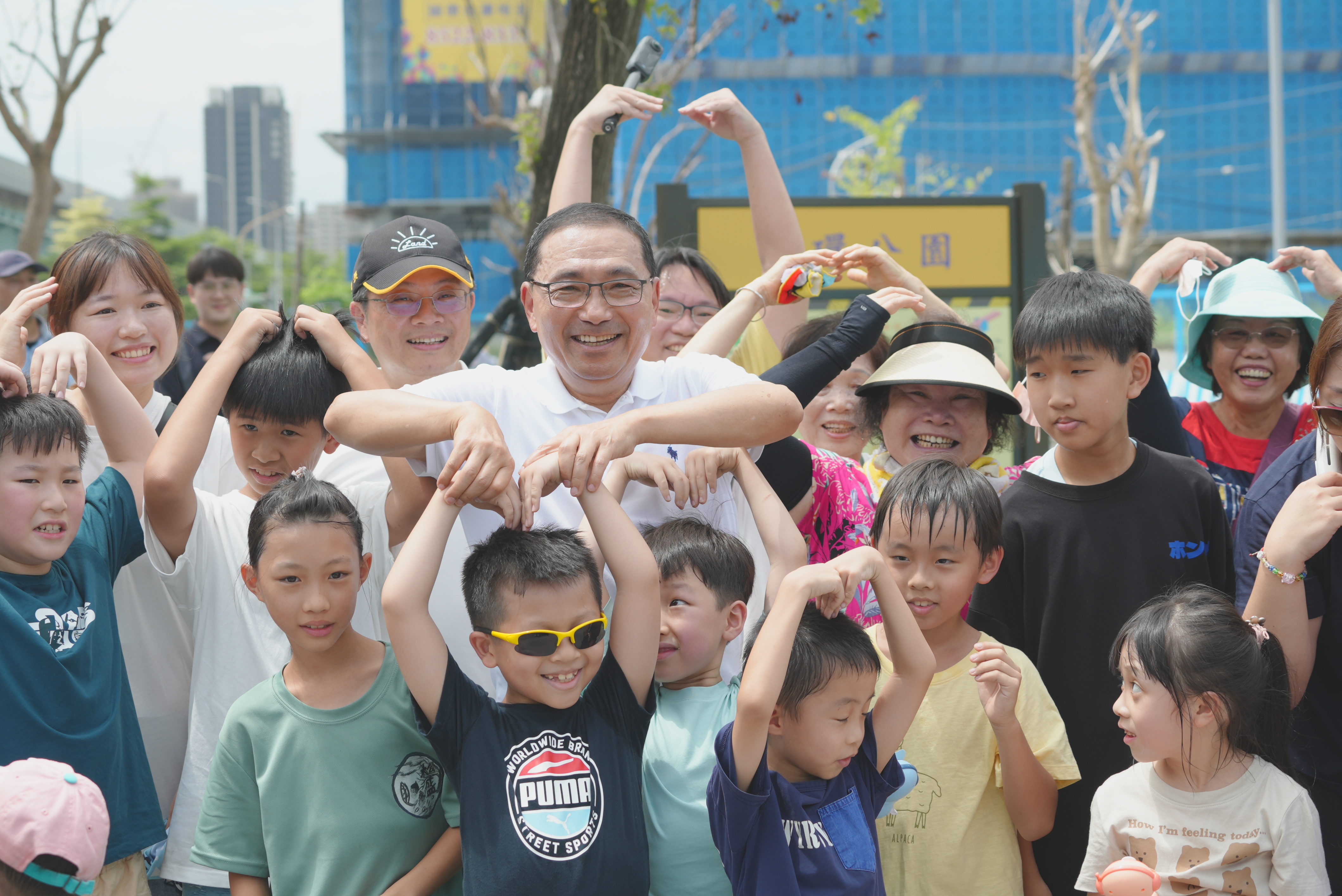 新北市長侯友宜與地政局員工子女在公園裡合影。新北市地政局提供
