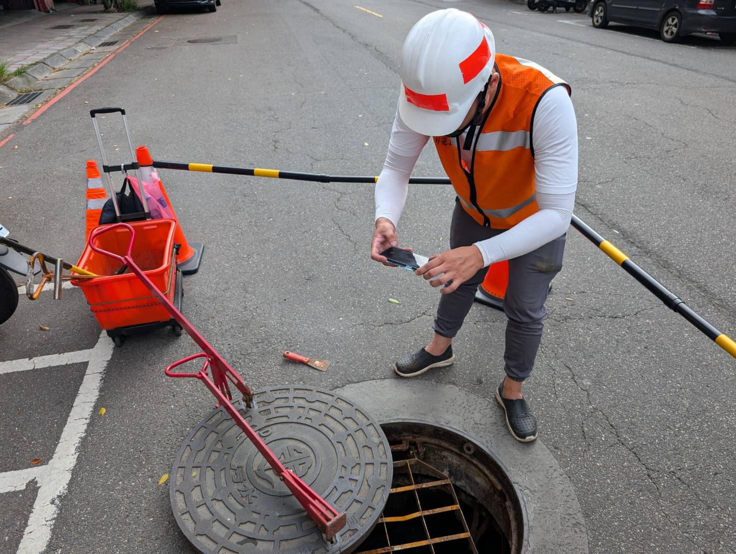 巡查人員檢視污水人孔內部，確認人孔陰井設施現況