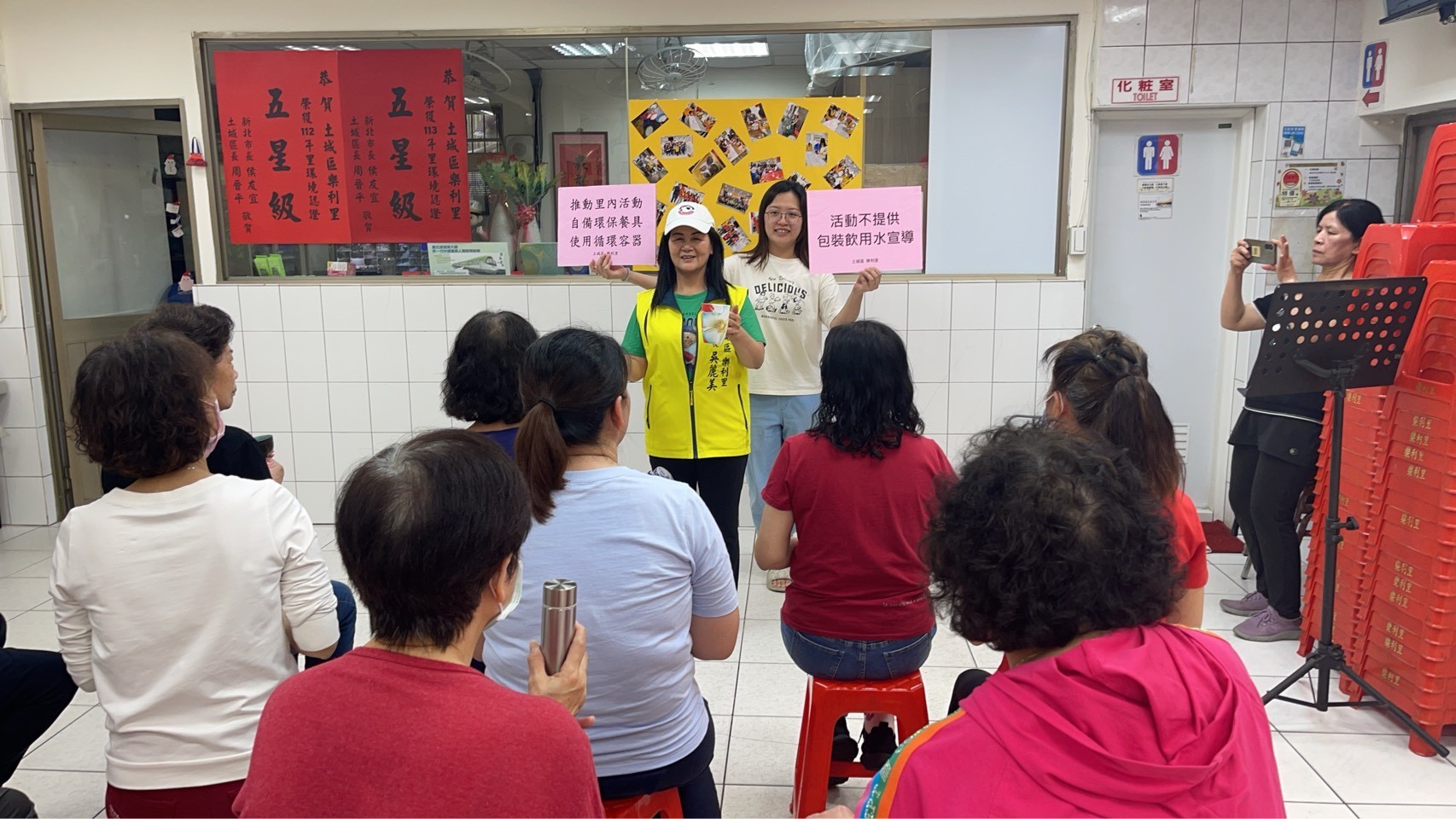 「環保青年組」得主羅雅馨，參與推動社區環教課程(舉手舉牌的女士)