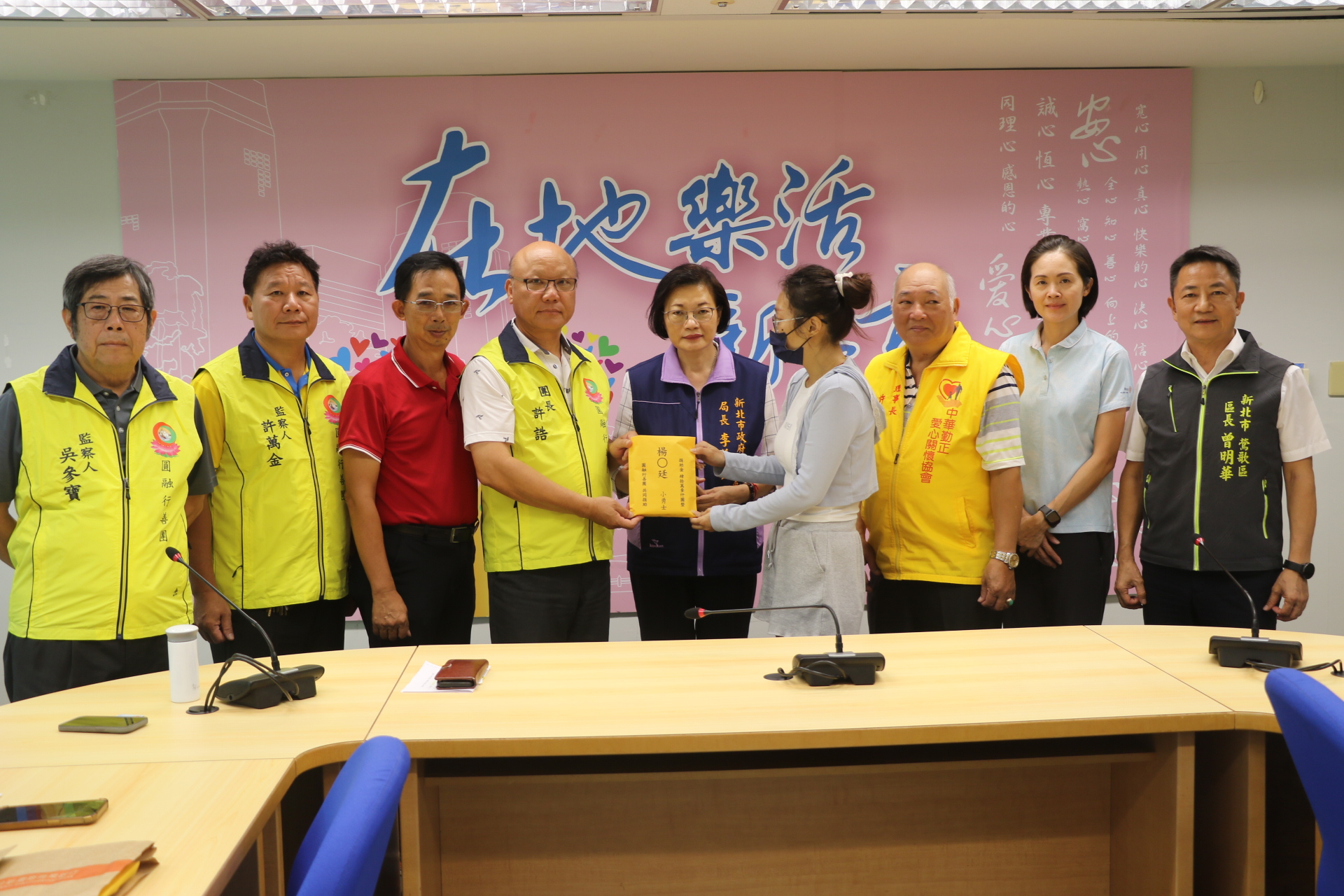 圓融行善團團長許誥（左4）、一竹慈善會理事長陳輝韓（左3）、中華勤正愛心關懷協會理事長許有來（右3）、鶯歌區長曾明華（右1）、市議員洪佳君（右2）等，一起將善款交給楊母。中為社會局長李美珍