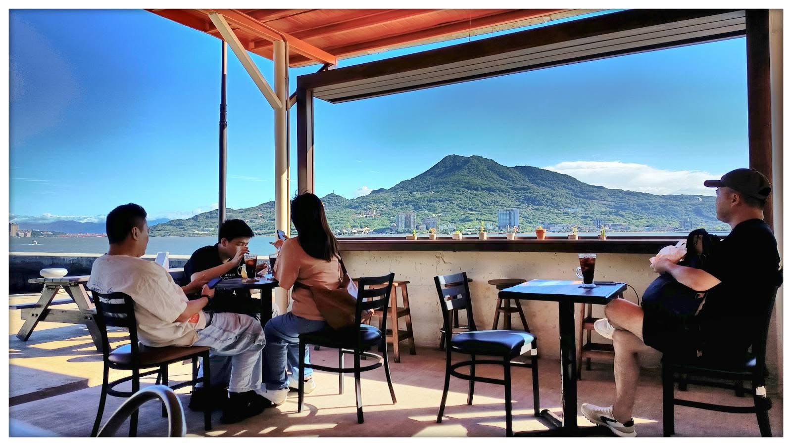 淡水漁文影像館外設有小憩空間邊，邊喝飲品邊欣賞山河美景 (陳耀旭館長提供)