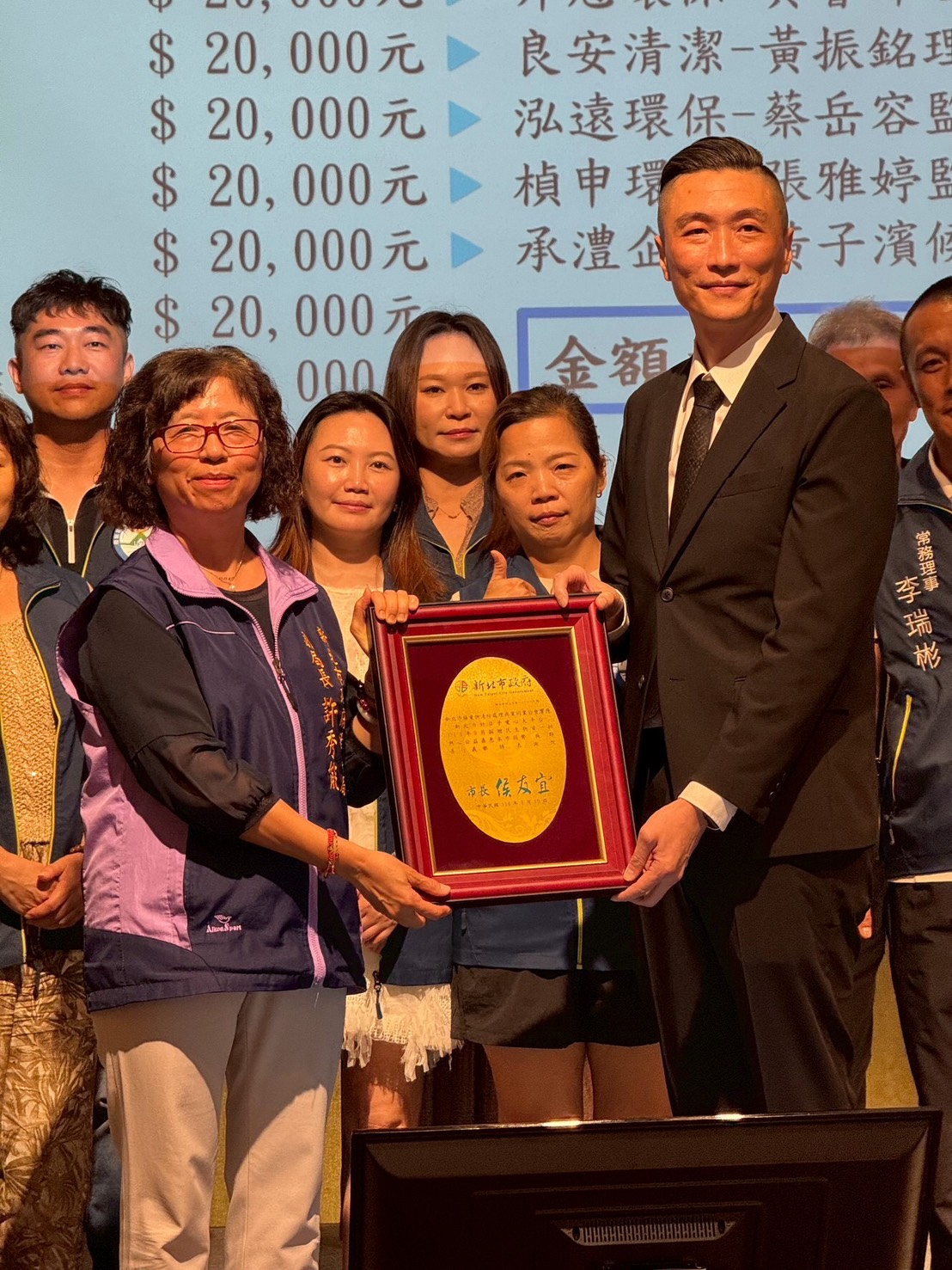 新北社會局副局長許秀能(左)代表巿府致贈感謝牌予新北巿廢棄物清除處理商業同業公會理事長林煌章(右)