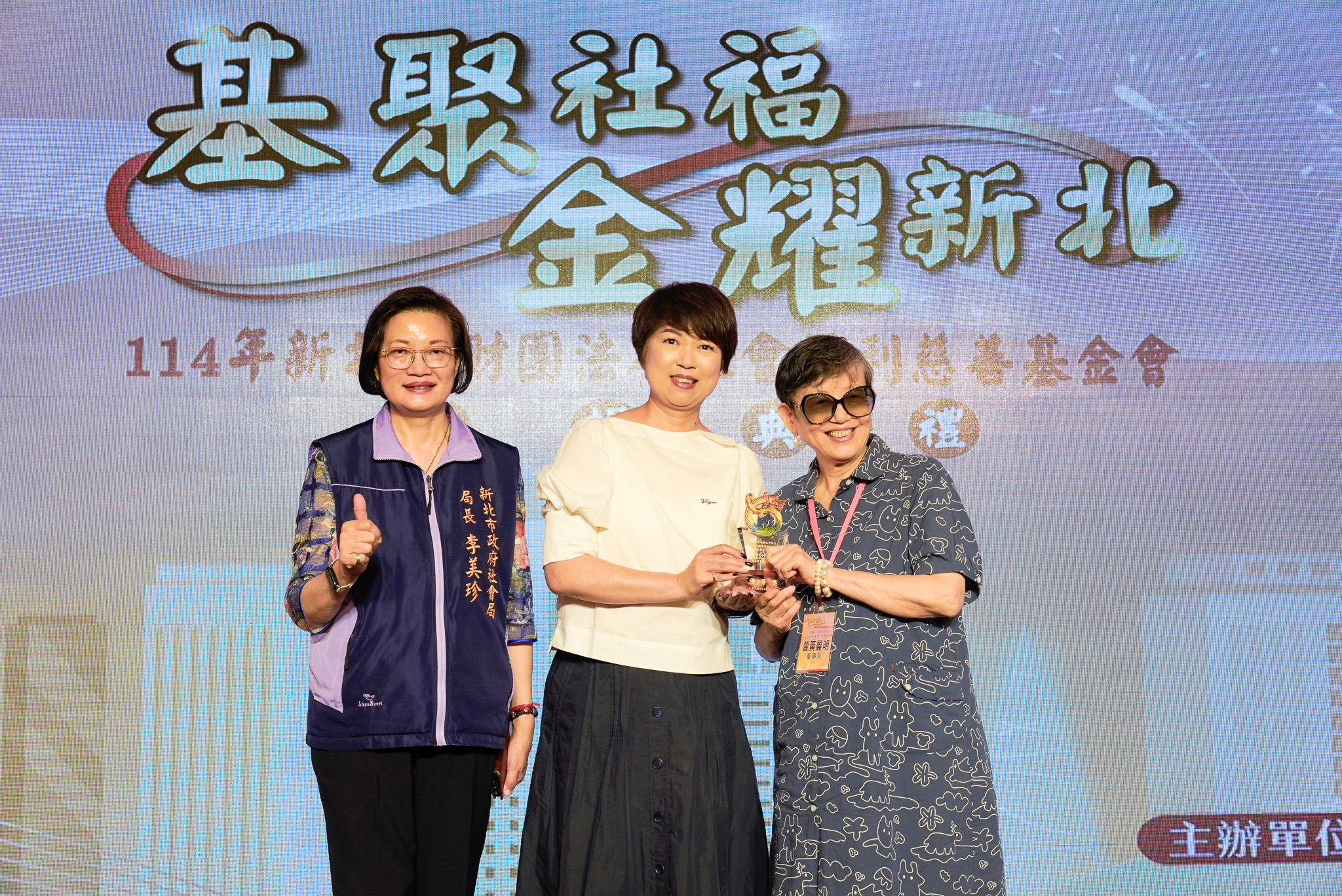 新北市副秘書長龔雅雯（中）代表侯友宜市長頒獎表揚瀚邦國際社會福利慈善事業基金會董事長曾黃麗明（右）