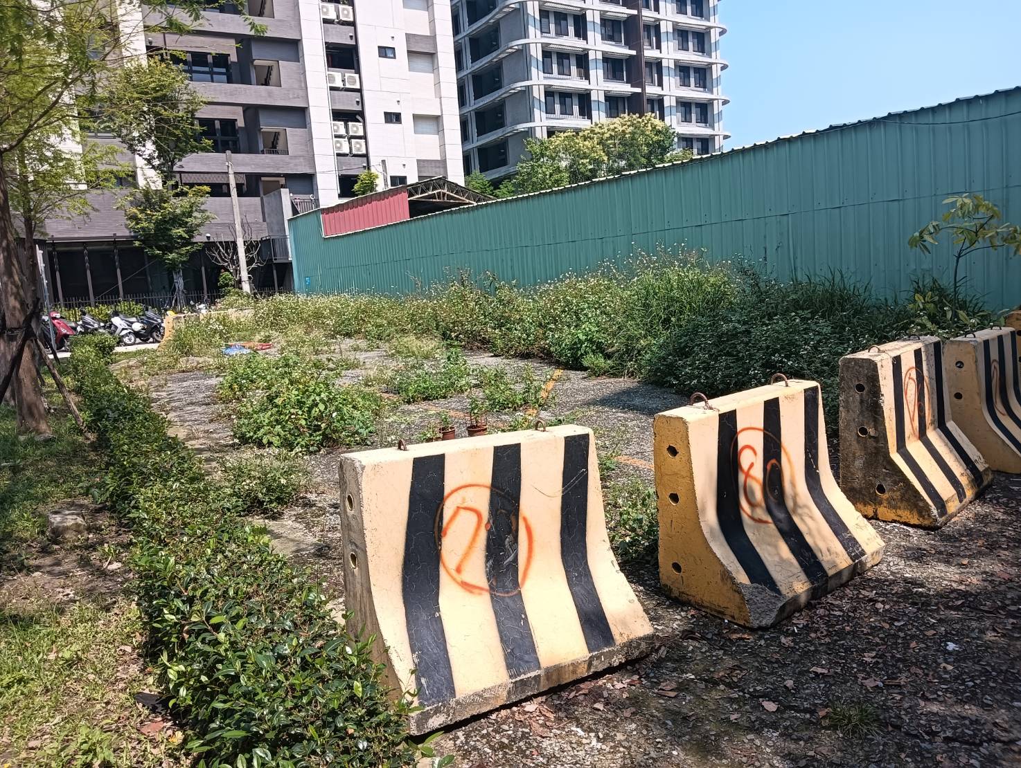 圖說： 新北市板橋區藝文一街與中正路379巷交界處有一公私共有的閒置空地，長期荒廢雜草叢生，養工處透過跨局處合作推動「新北美樂地2.0」專案，清除雜物也改善鋪面，並新增54個YouBike停車車柱，讓空間煥然一新。圖為改善前。