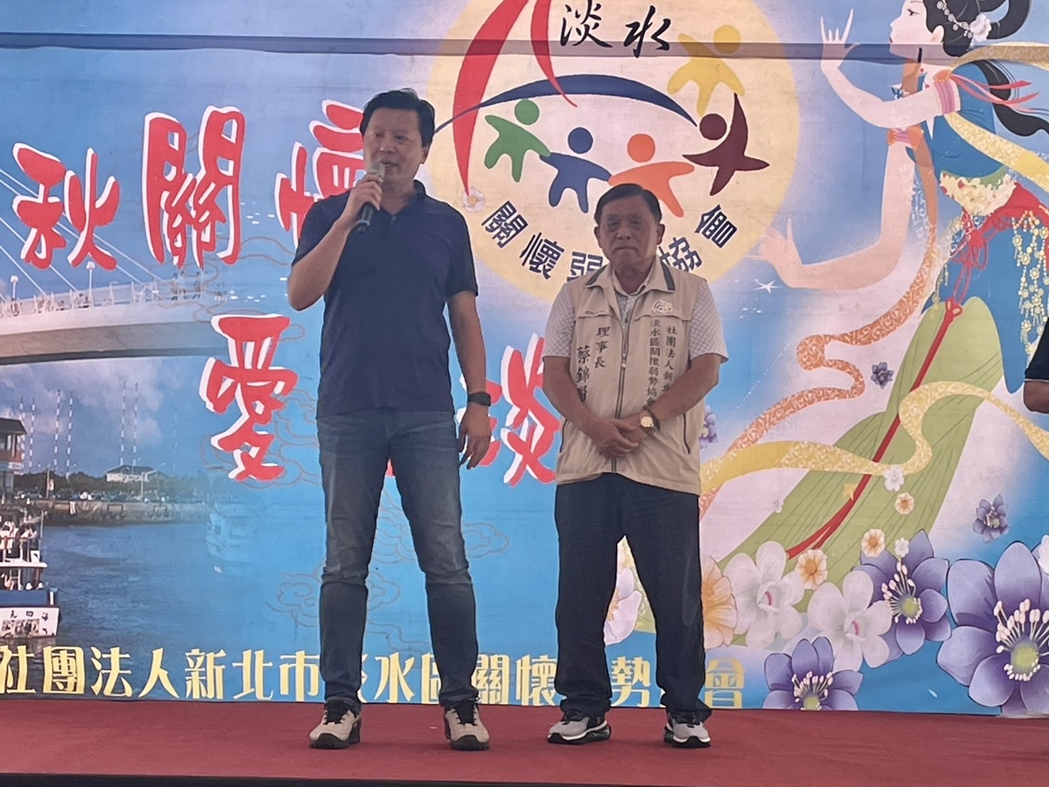 新北副市長朱惕之（左）出席活動致詞，向淡水區關懷弱勢協會蔡錦賢理事長（右）18年善舉表達感謝