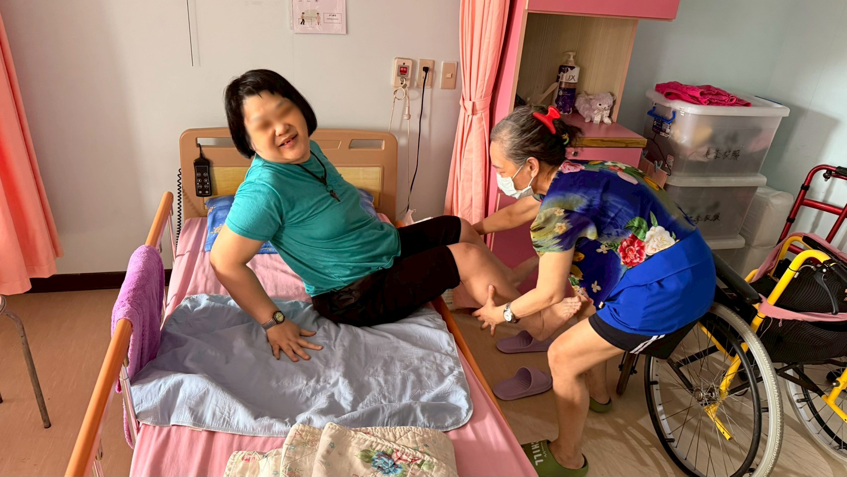  小梅(右)在護理之家幫忙其他住民移位到床上