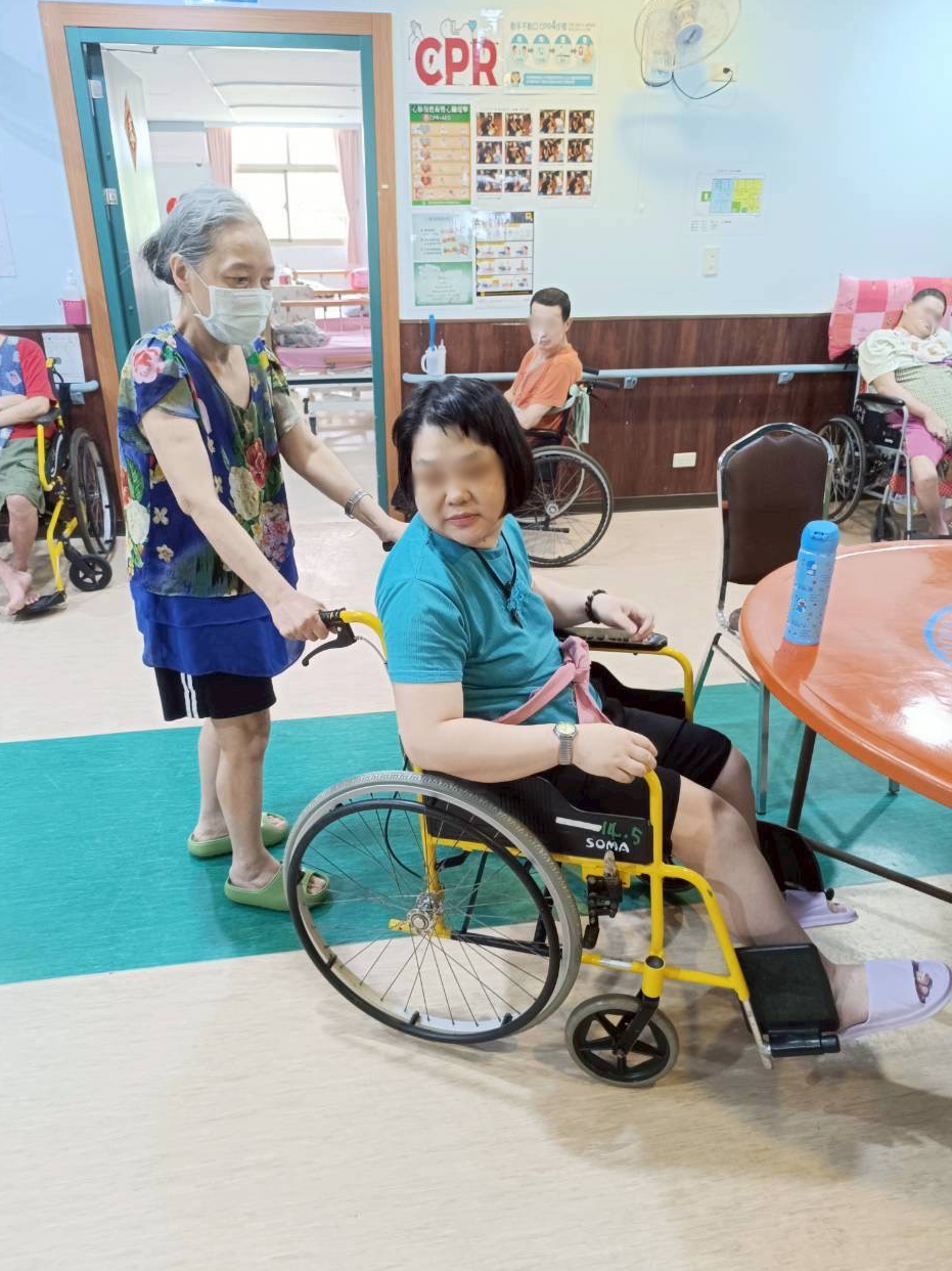  小梅(左)在護理之家幫忙其他住民推輪椅活動