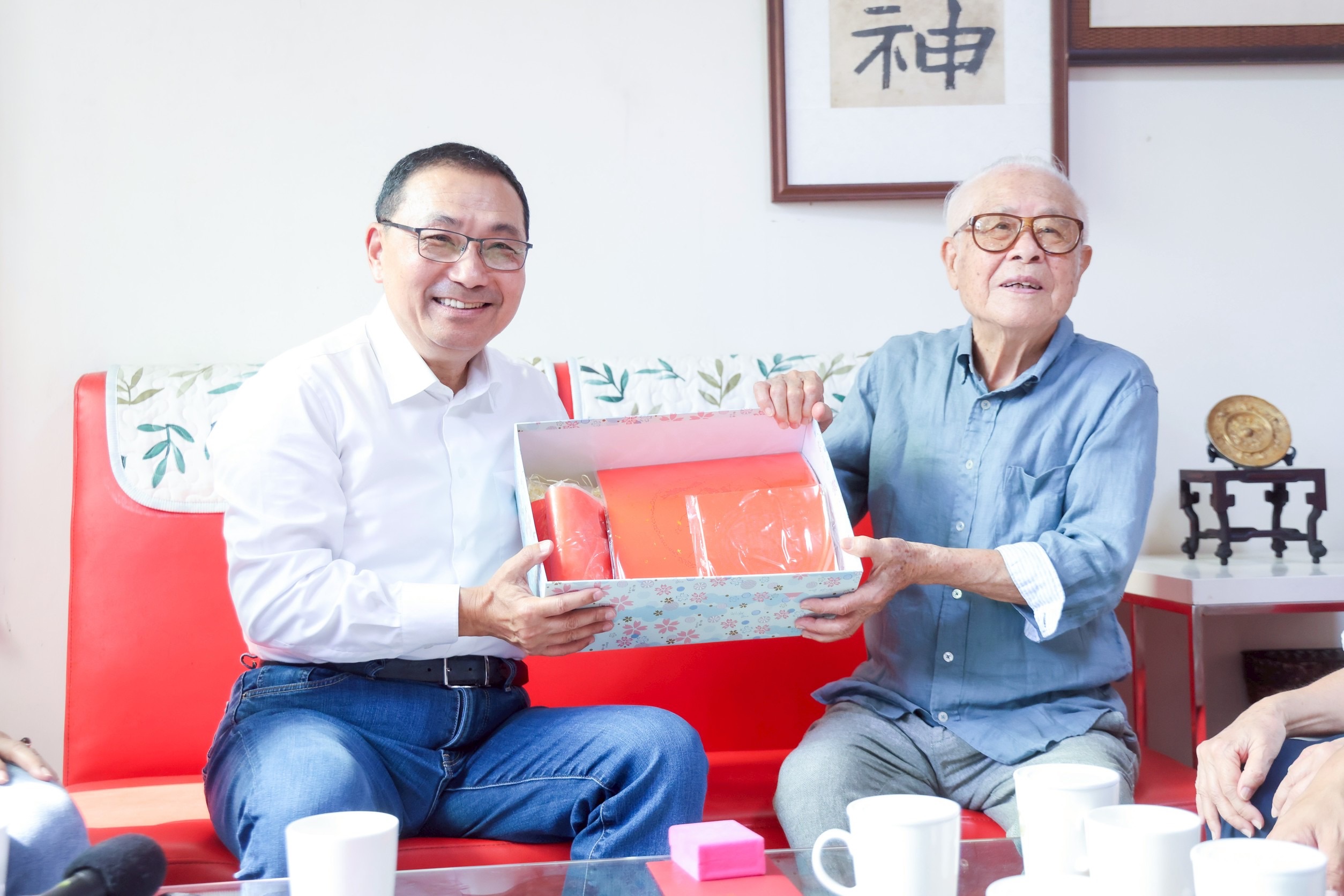 侯友宜今探視102歲人瑞沈軏，並親手送上紅宣紙與金鎖片，表達祝福之意。