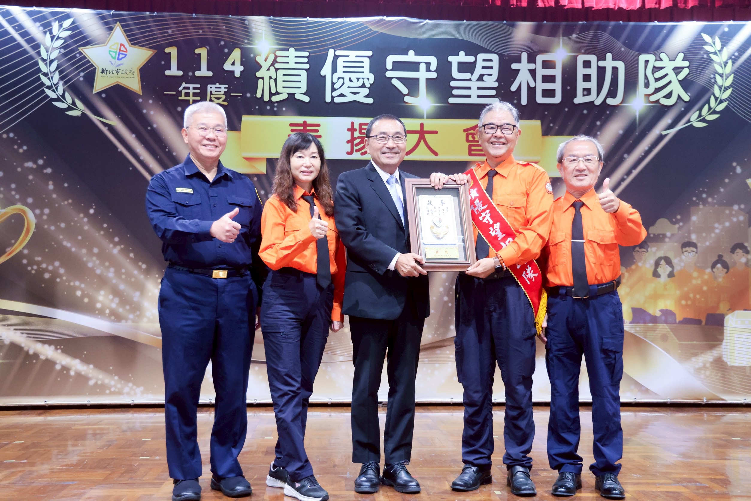 新北市政府今(21)日舉辦「114年績優里守望相助隊」表揚大會，由新北市市長侯友宜頒獎表揚81位獲獎的守望相助隊(里)長，並向辛苦的守望相助隊致敬。