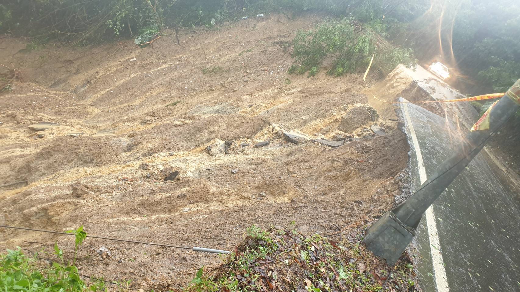 圖說：汐止區長青路210巷因雨勢不斷，造成邊坡土石滑落，影響通行，養工處立即調派人員及機具到現場搶修。
