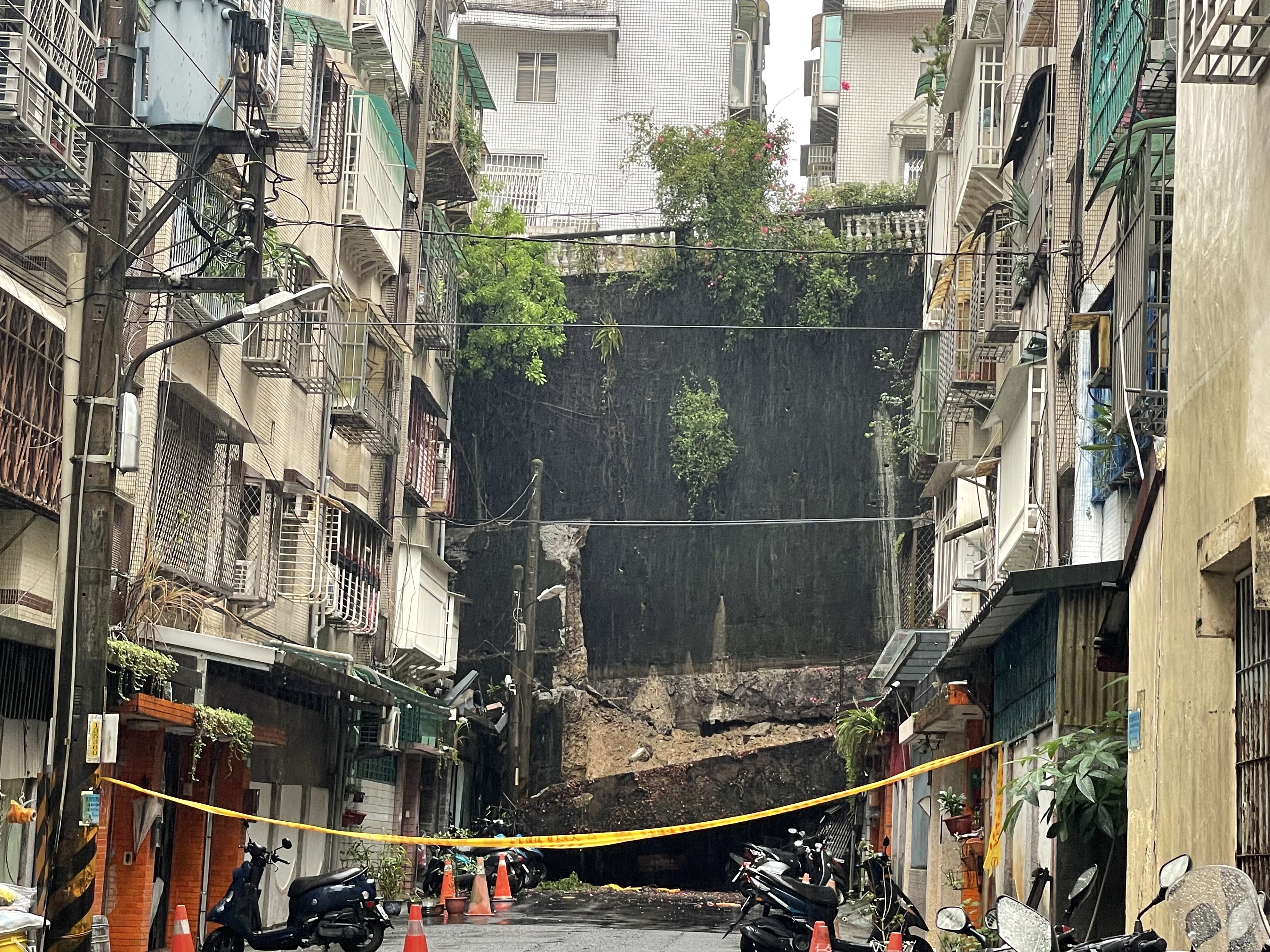 新店區錦繡、碧瑤社區間擋土牆發生坍塌，現場拉起封鎖線，工務局緊急調派人員與機具到場搶災。