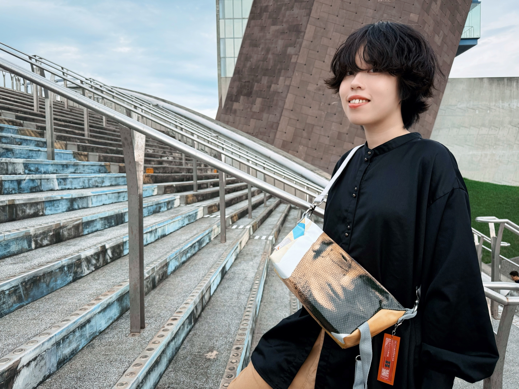 布面上印有鎮館之寶「人面陶罐」的微笑輪廓。