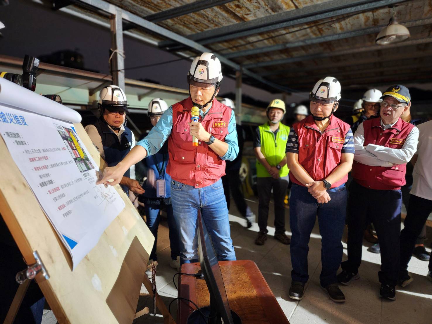 朱惕之副市長（左ㄧ）也前往社區，說明邊坡及擋土牆復原工法。