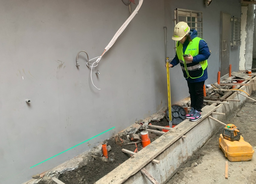 工程人員在後巷埋設污水管後，進行管線坡度查驗，確保水流順暢