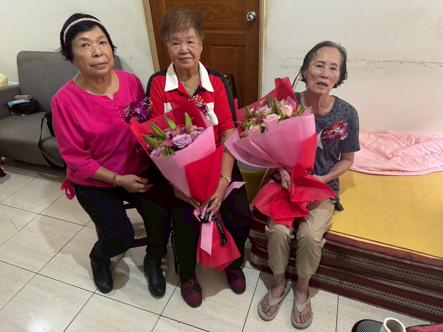  新北市眾能創新協會理事長黃芯愉（左）特別為江紹琴（右）和許蔡勸（中）兩位阿嬤獻上花束和紅包 祝福生日快樂