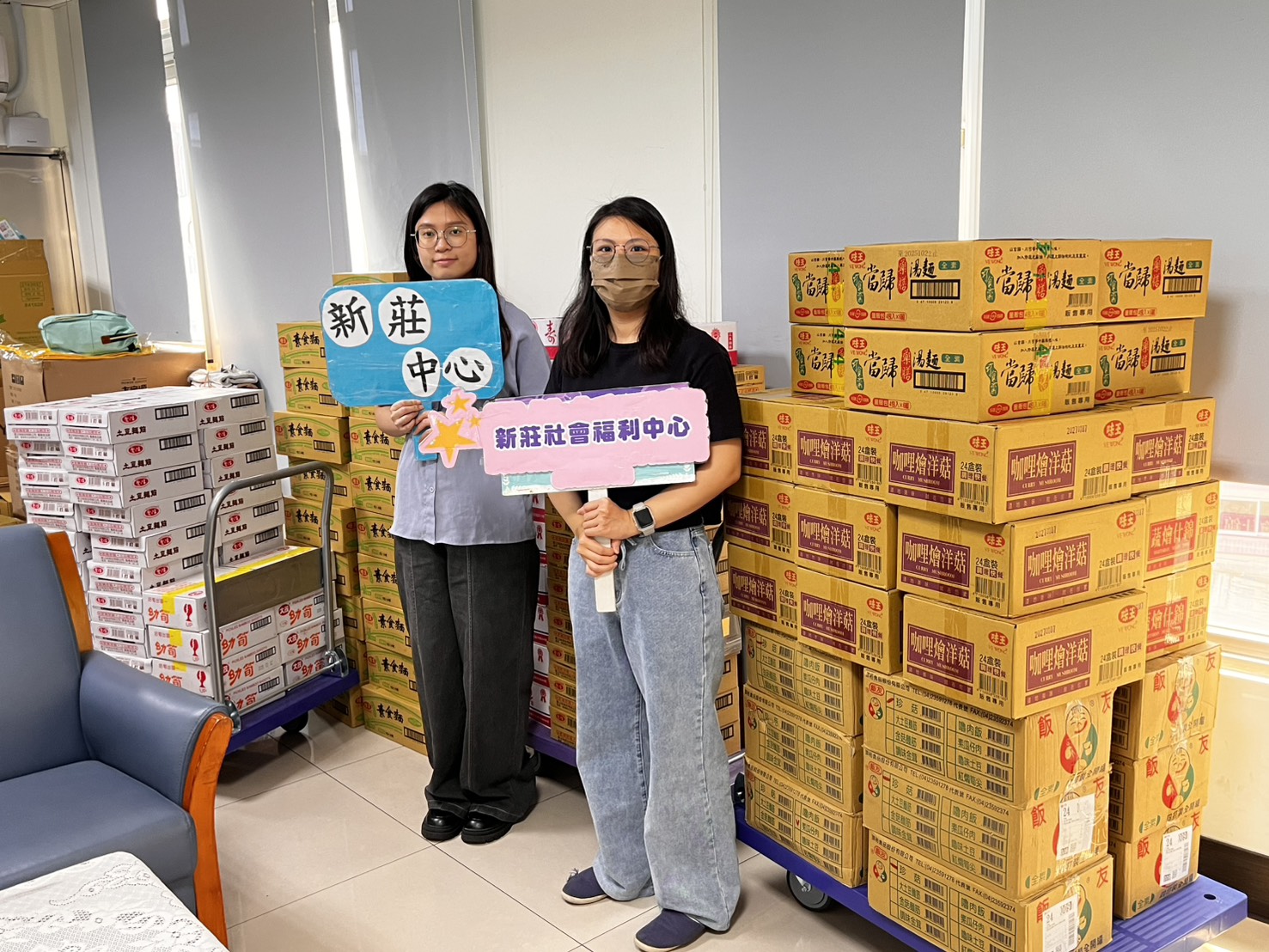  新莊社福中心社工陳姵勳（右）和徐思頴整理天極佛堂請廠商直接送來的各式食品物資