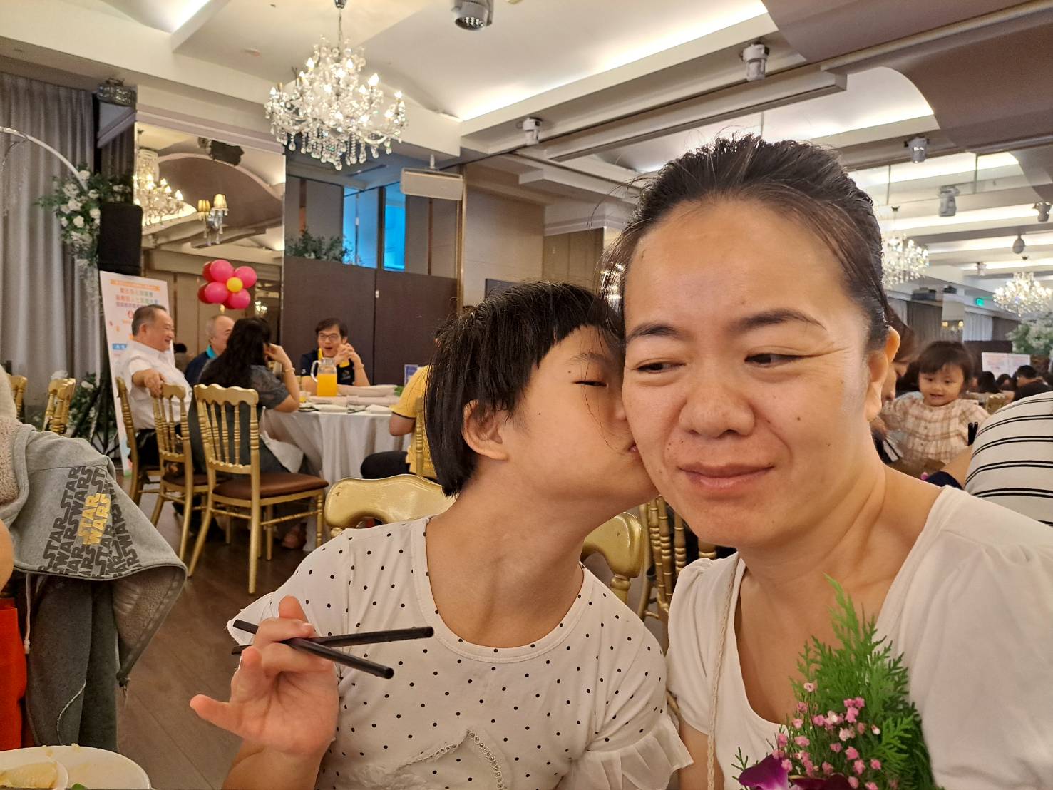  小鈺在表揚會場餐會中 親了陳立群 感謝媽媽的照顧