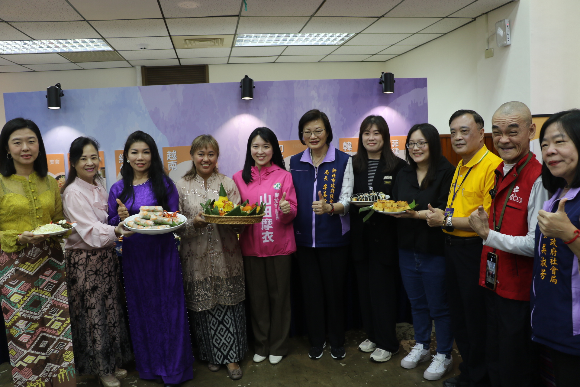 李美珍局長與東南亞新住民各自端著自製的家鄉美食 新住民以美食解鄉愁