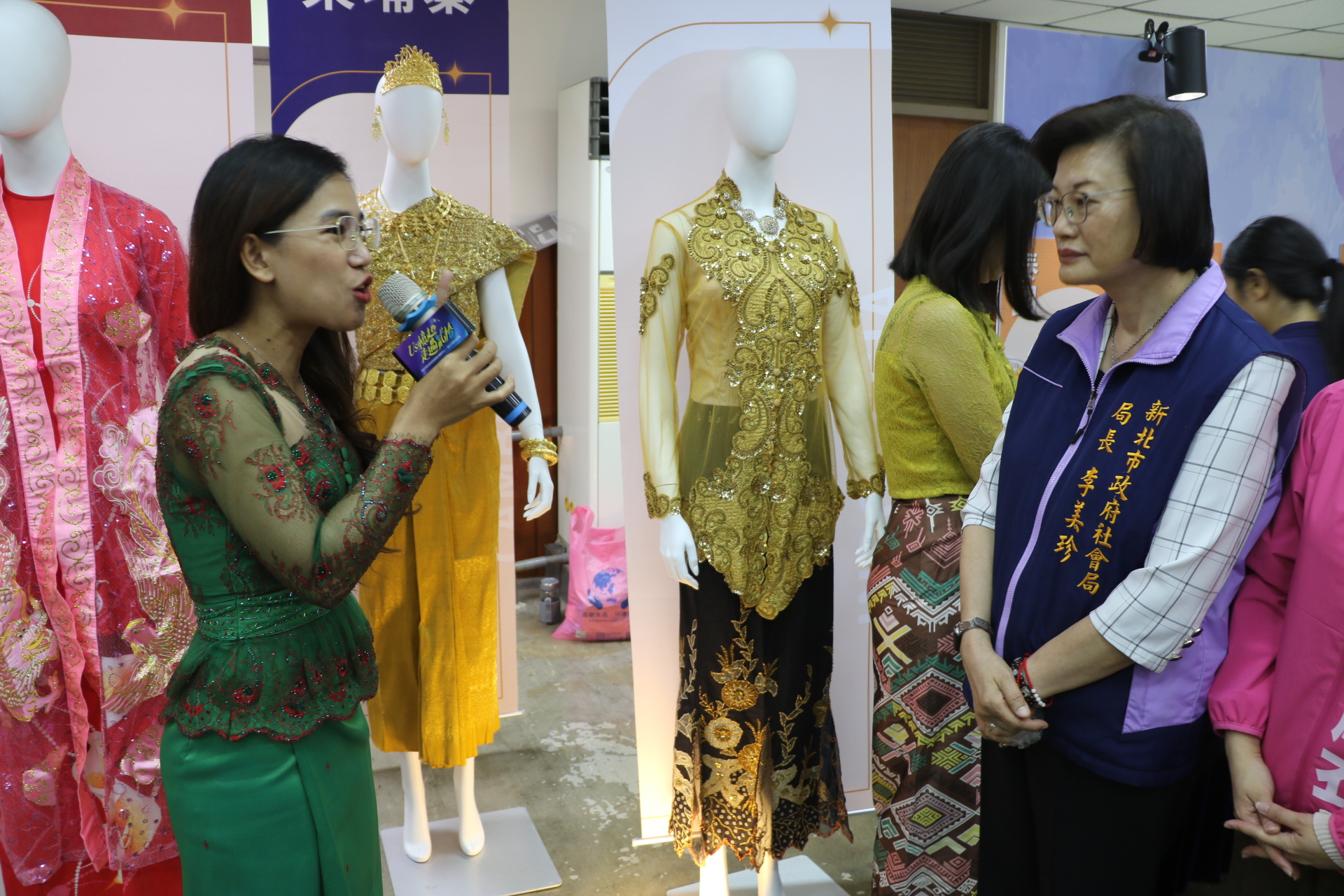  來自柬埔寨的潘喜玲為李美珍局長解說東南亞各國的服飾