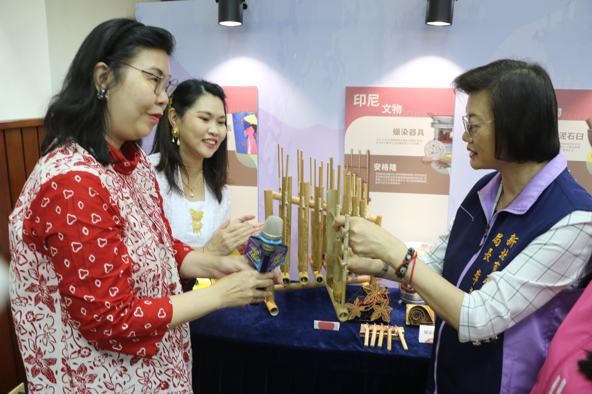  印尼新住民盧美華（左1）為李美珍局長示範傳統樂器安格隆（搖竹） 李美珍試著搖動演奏