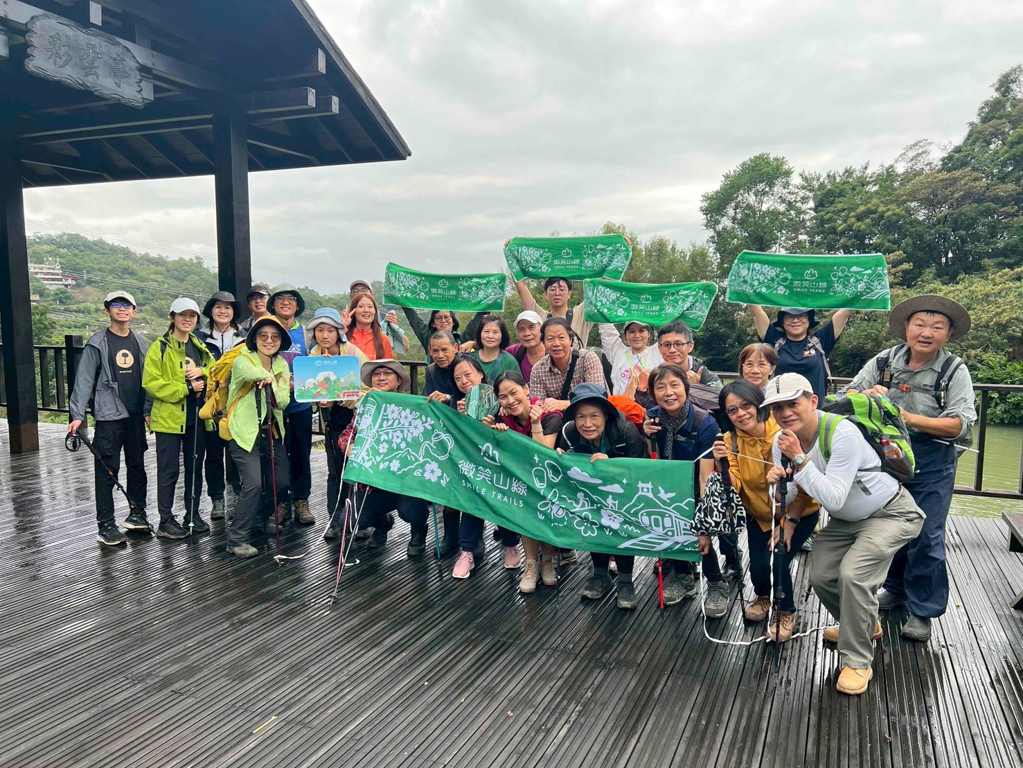  參與者手持活動旗幟與標誌，紀錄此次健行成果。