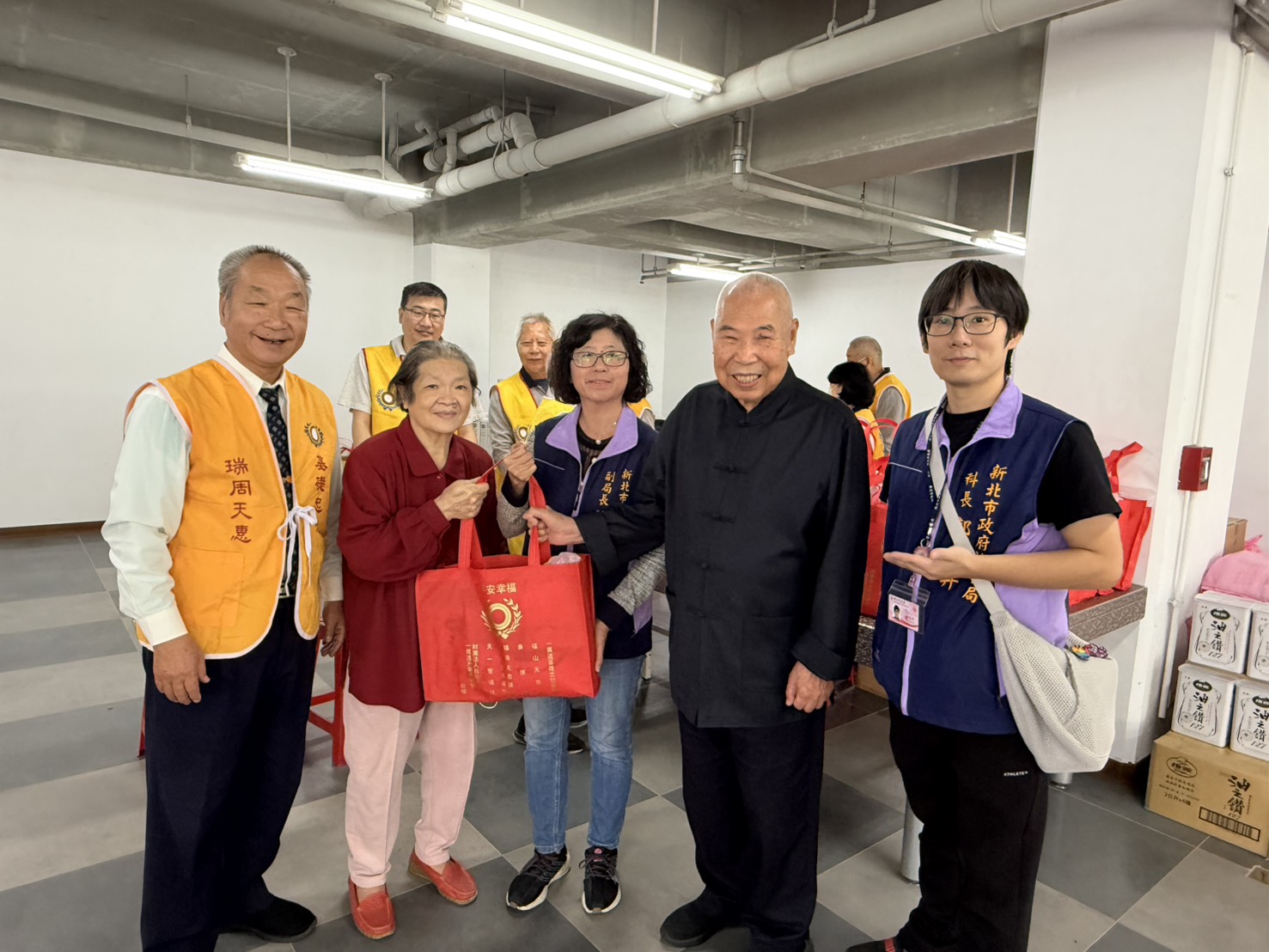 社會局副局長許秀能(中)與天惠堂主委李邦雄(右2)及點傳師林正修(左1)，將物資交到弱勢家庭手中