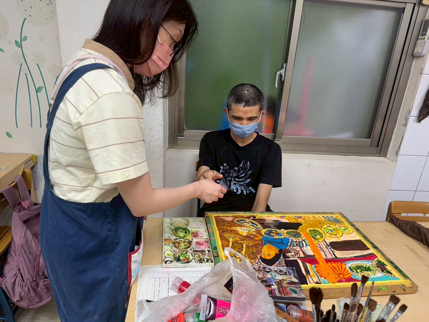  呂俞賢平時作畫的模樣 左為指導老師吳乃萱