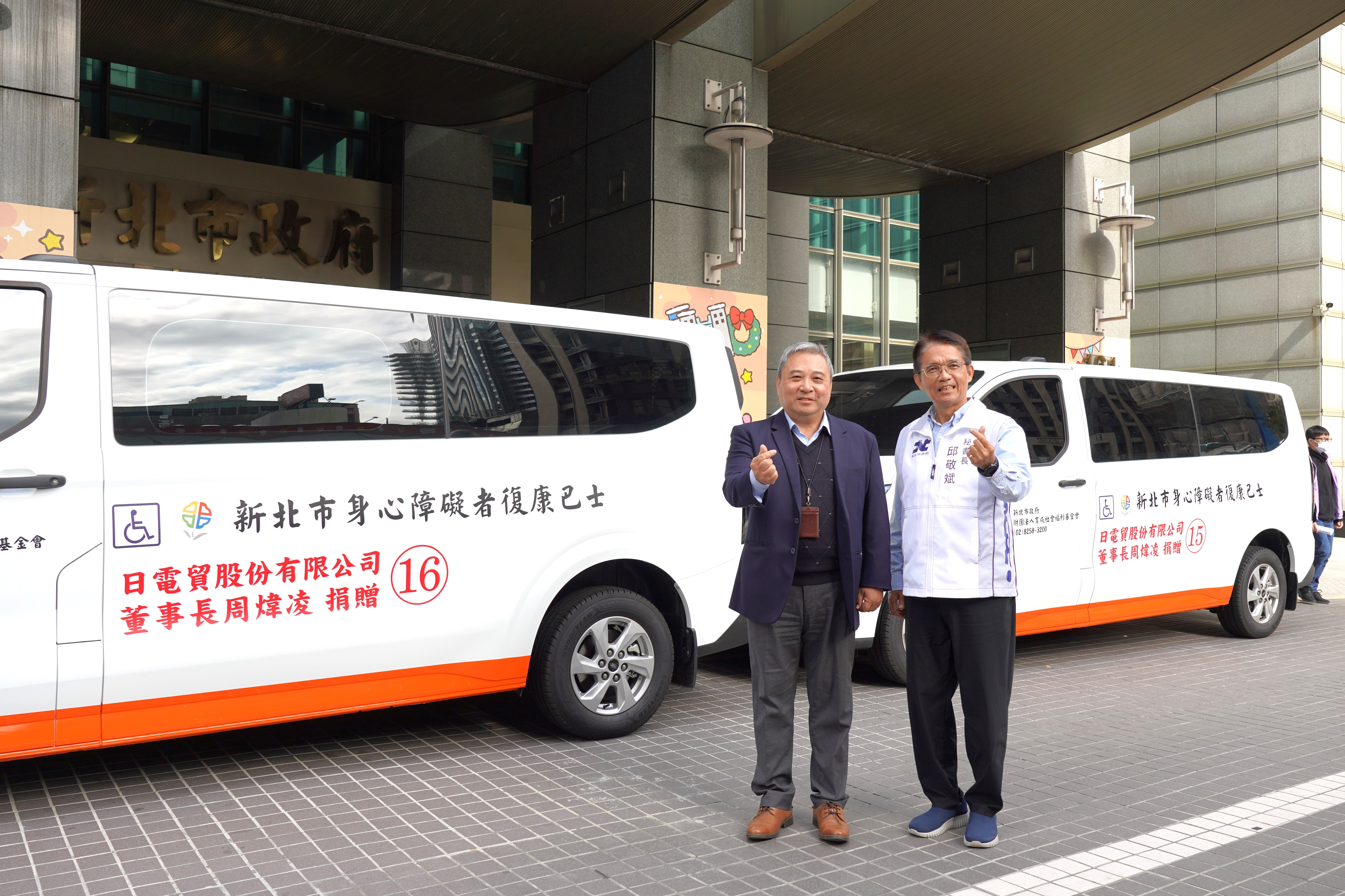 日電貿股份有限公司4日由副董事長李坤蒼(左)代表，捐贈2輛可同時搭載2台輪椅的復康巴士給新北市政府，由市府秘書長邱敬斌代表受贈(右)。