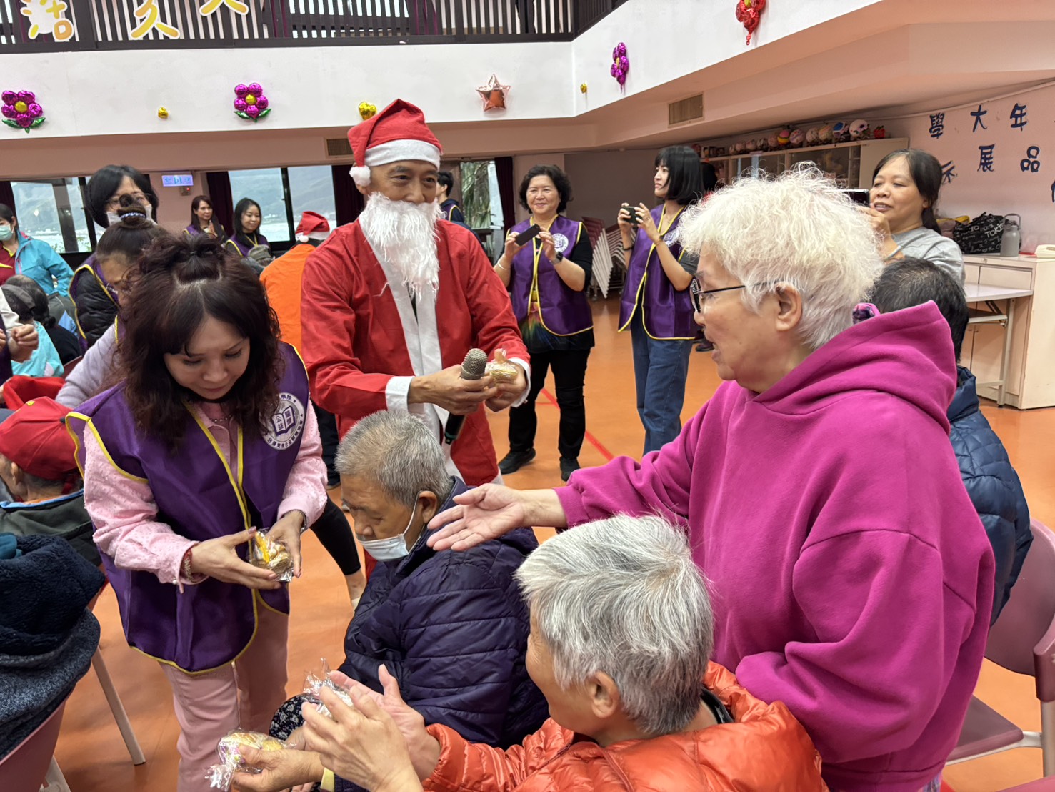  紫微公益協會的志工化身聖誕老公公，逐一送長輩聖誕禮物