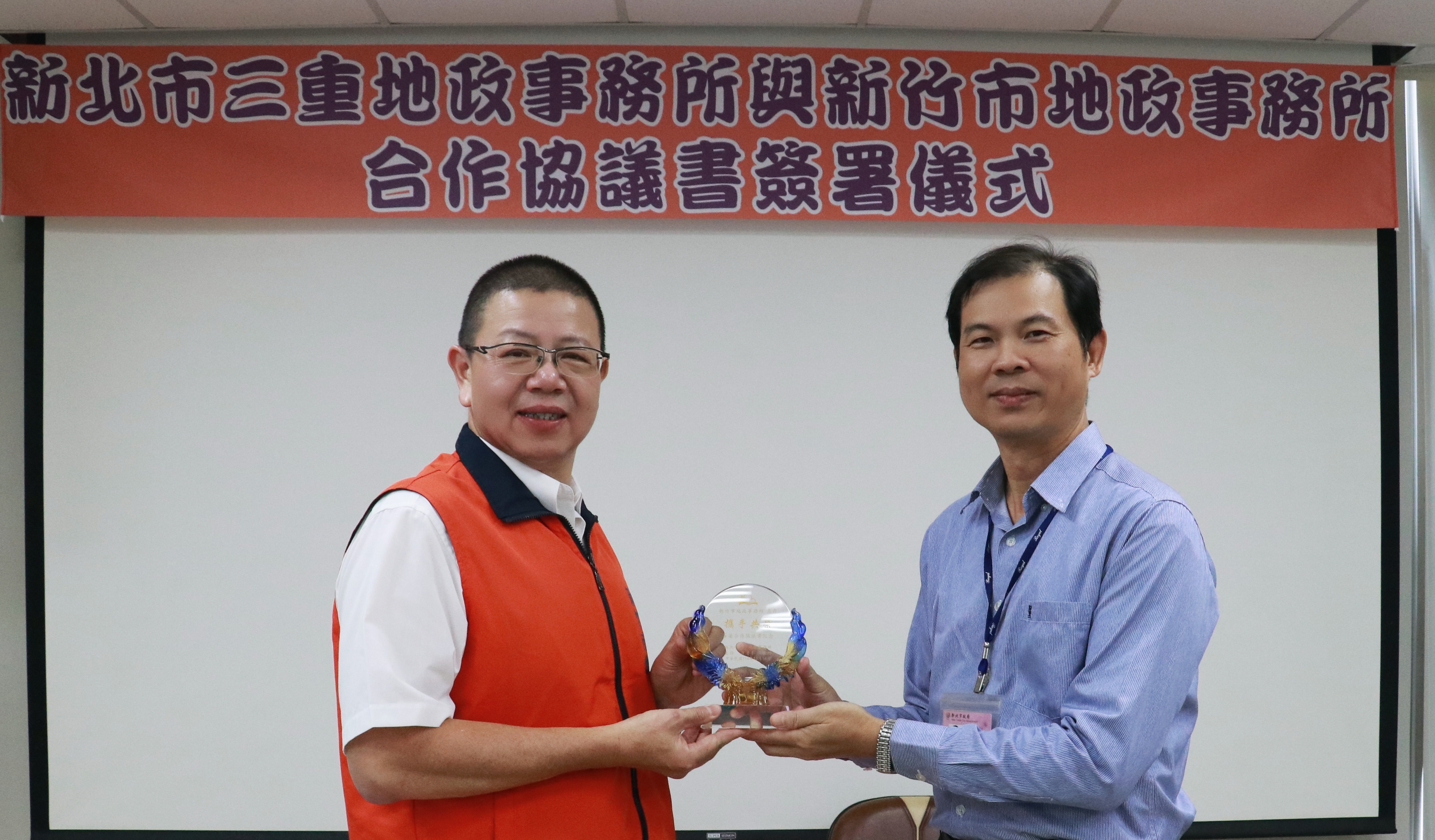 新北市三重地政事務所主任許才仁（右）與新竹市地政事務所主任蕭介峯（左）致贈合作協議簽署儀式紀念品。
