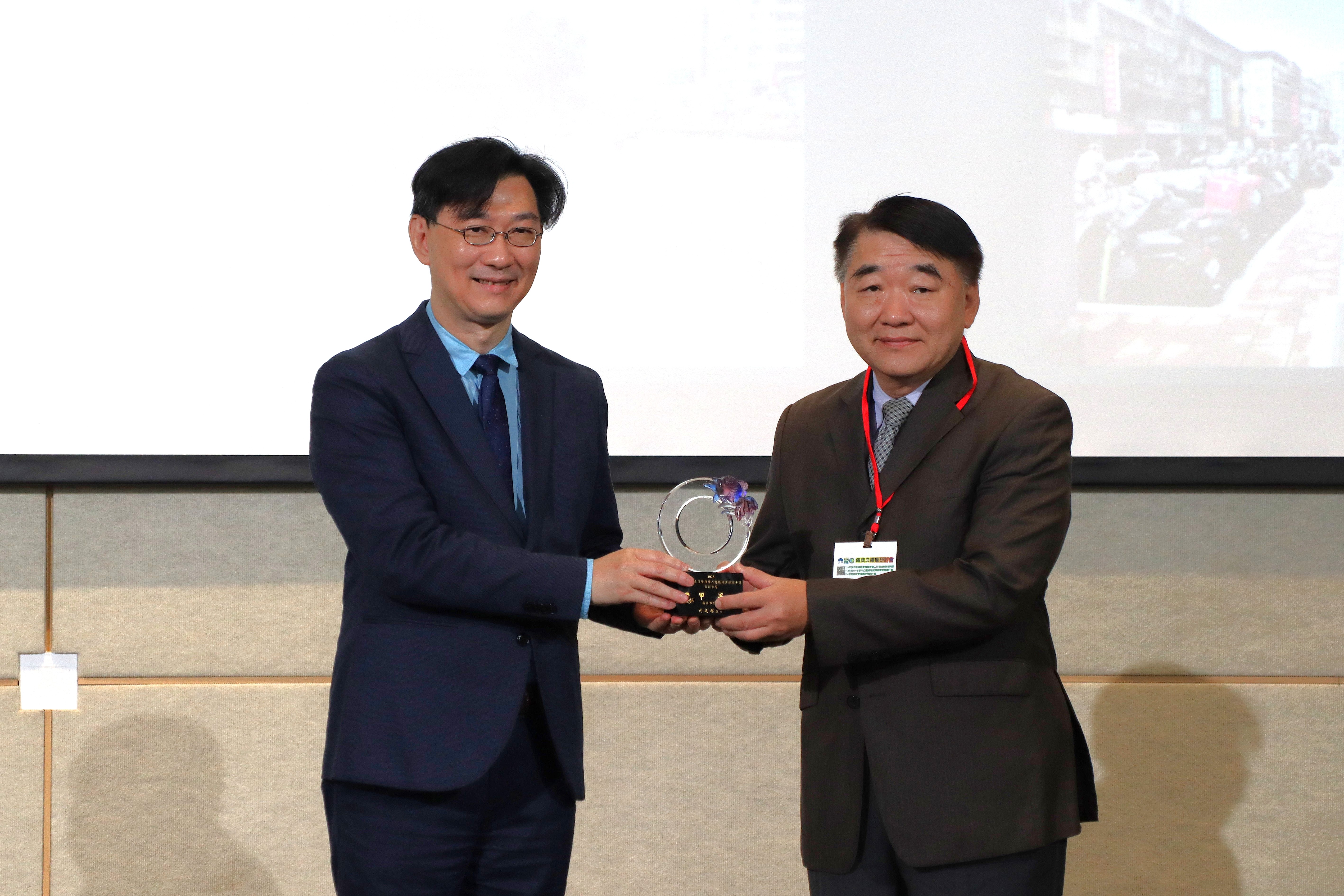 新北市共同管道、道路養護暨人行環境無障礙考評獲中央肯定，由工務局長馮兆麟(右)代表市府，接受內政部次長董建宏頒獎