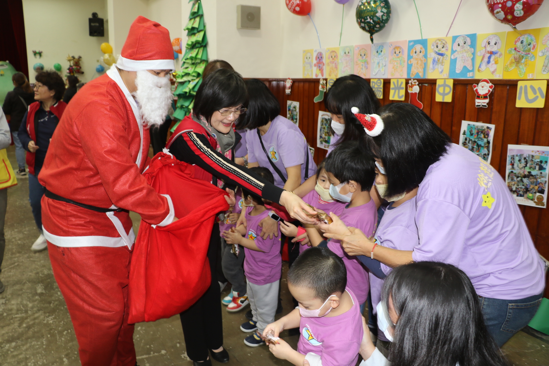  自閉症協進會理事長劉郁純（左2）和聖誕老公公一起發送禮物給星兒